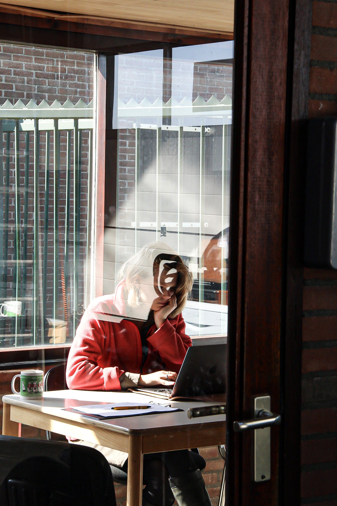 Ondernemer die geconcentreerd aan een project werkt in een creatieve studio, gefotografeerd met focus op zijn/haar natuurlijke en authentieke werkwijze