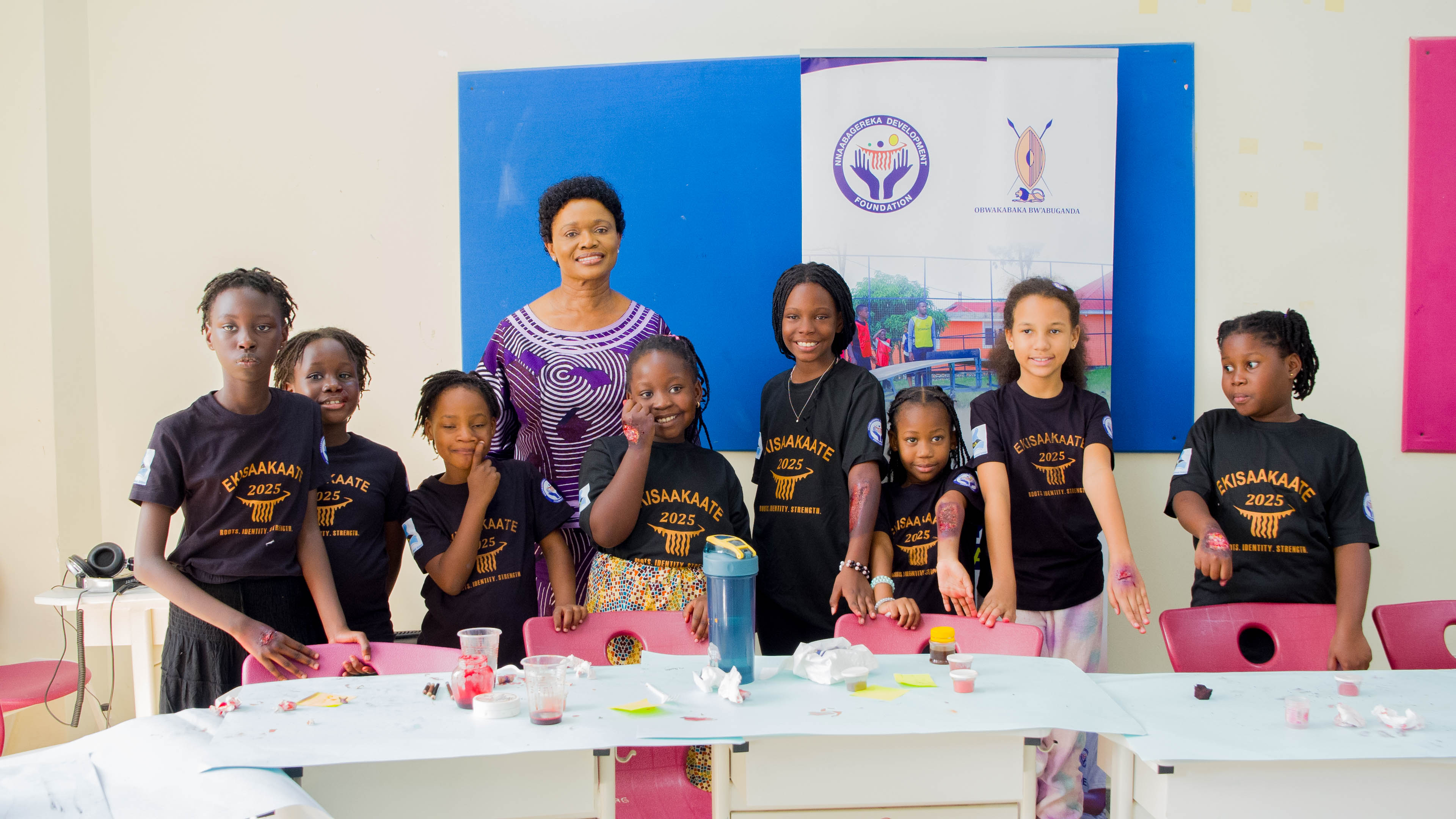 A student wearing a red uniform sits while holding a book in his hands