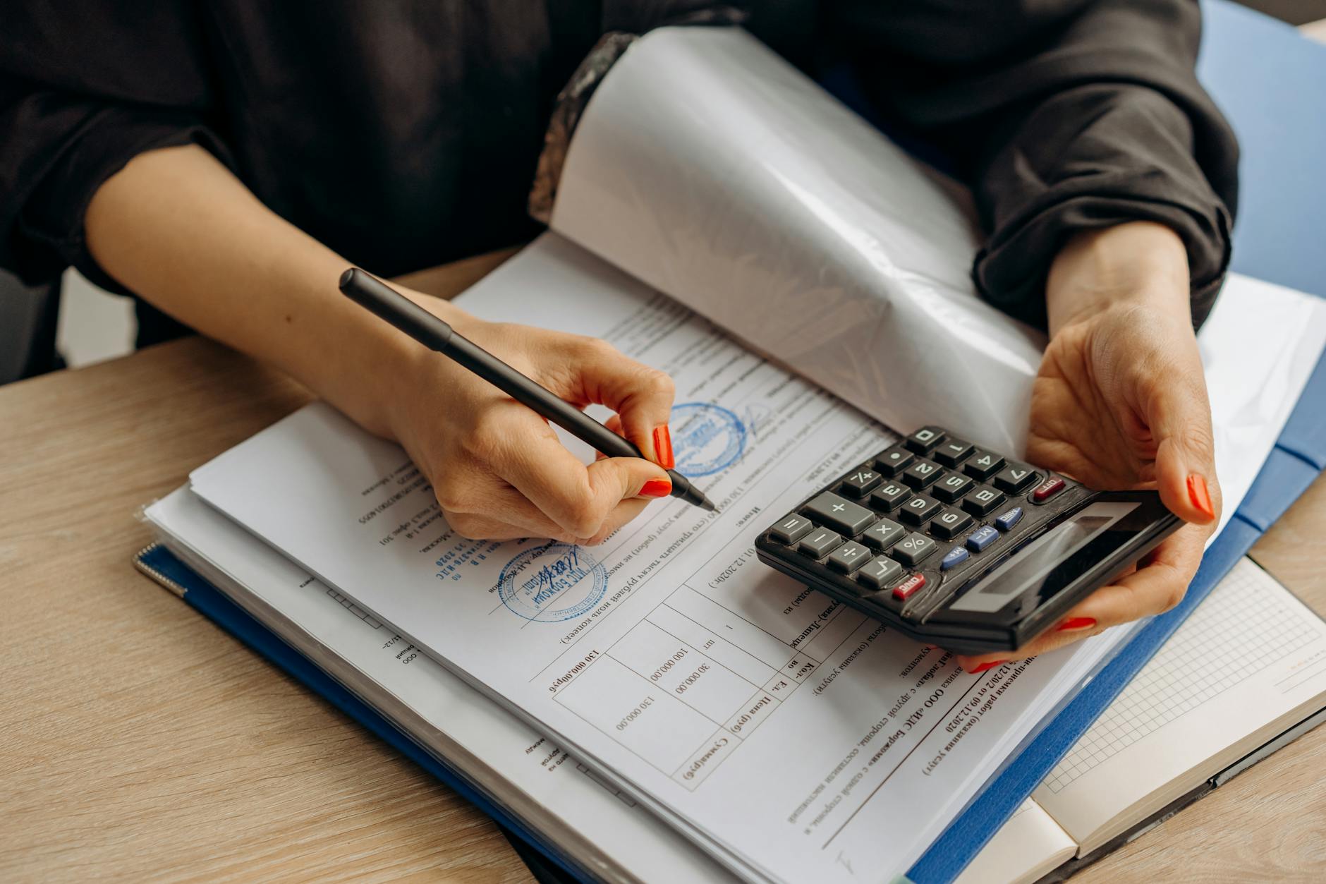Contabil verificand documente fiscale cu calculator si formulare