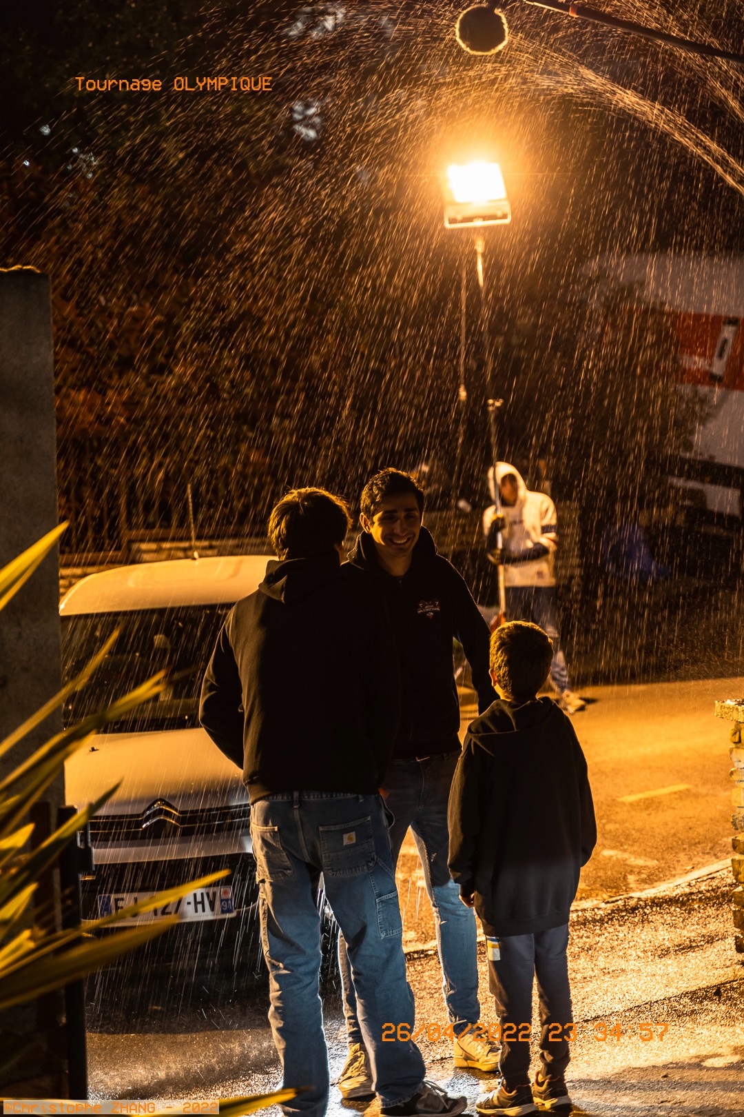 Acteurs sous la pluie artificielle pour une scène dramatique.