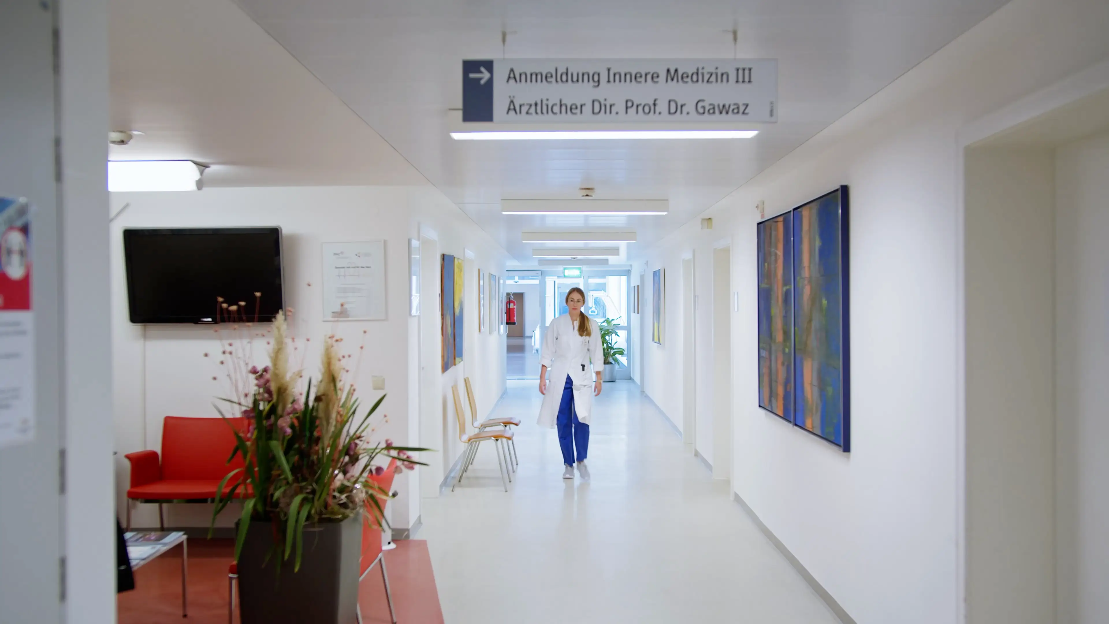 Ein weibliches Mitglied der Kardiologie Tübingen geht durch einen Flur.