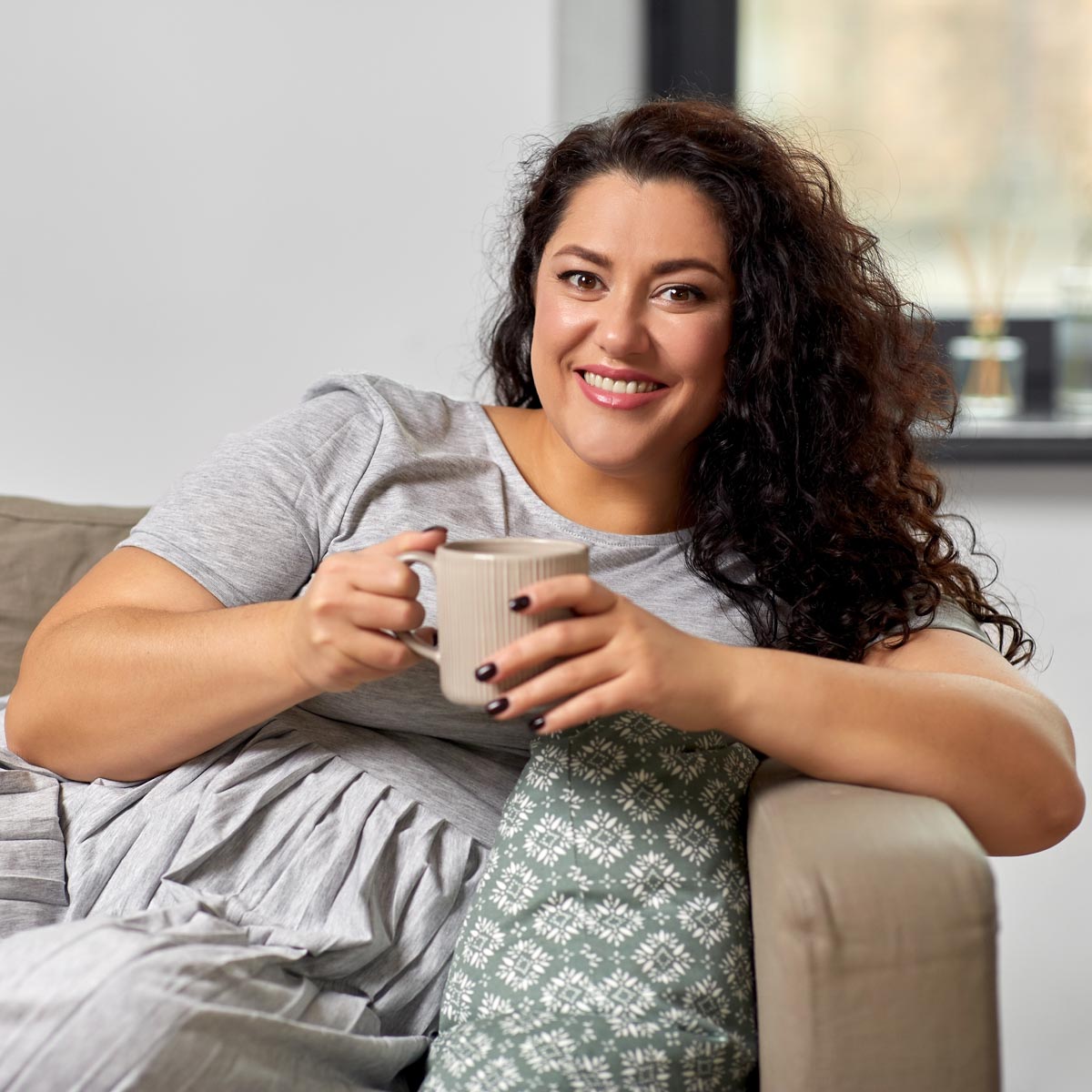 Woman enjoying a cup of coffee on a sofa