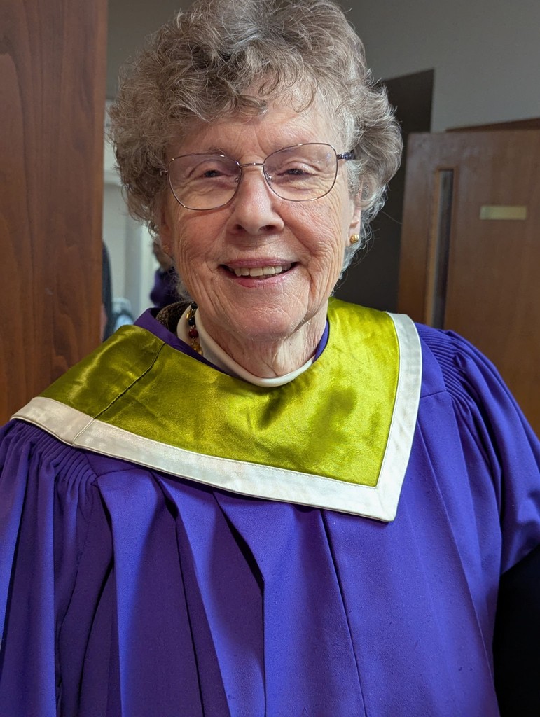 man in pink dress shirt wearing black sunglasses sitting on gray couch