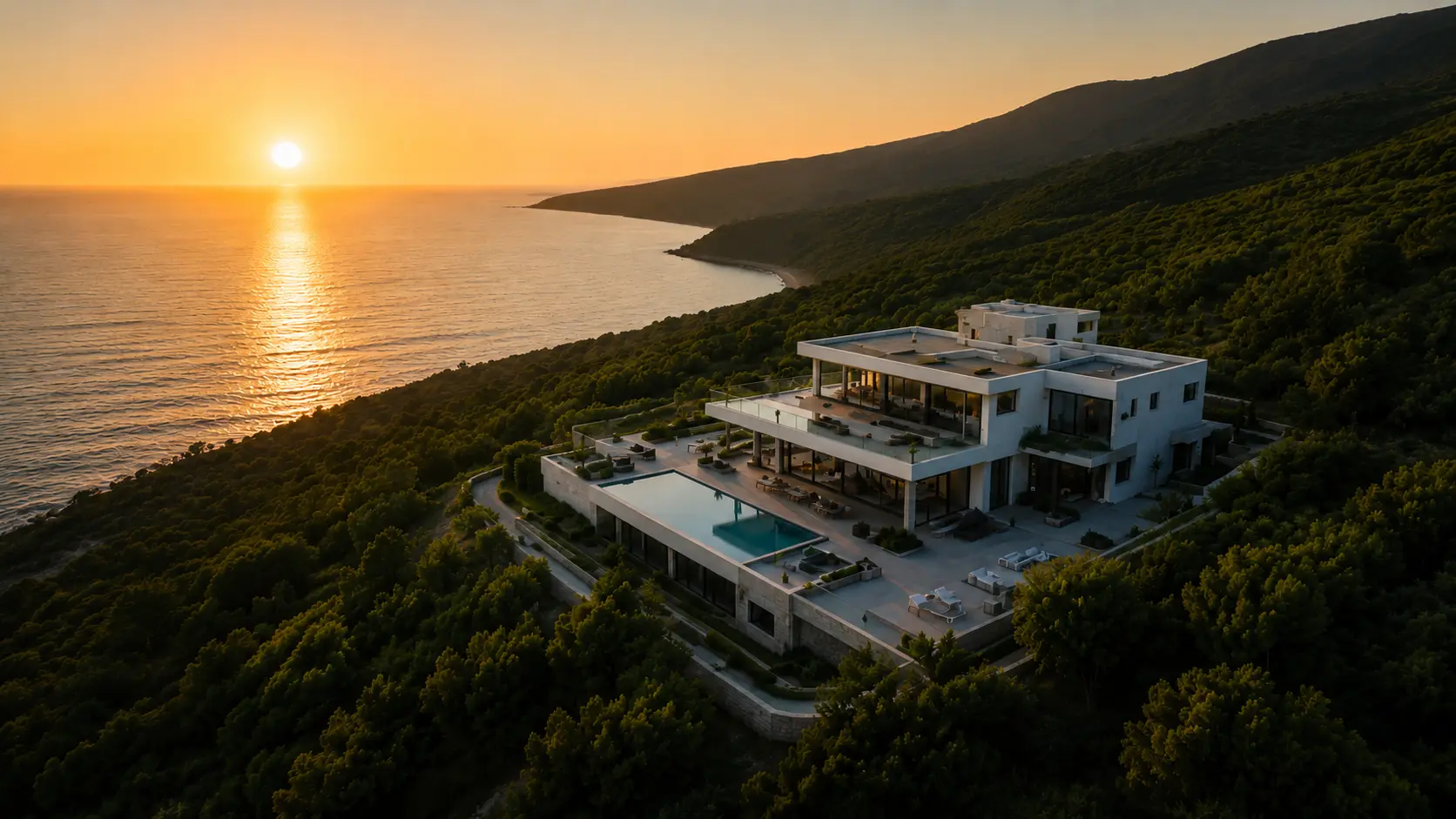 Vue aérienne d’une villa contemporaine en bord de mer sur la Côte d’Azur au coucher du soleil, illustrant les services photo et vidéo drone immobiliers toute l’année.