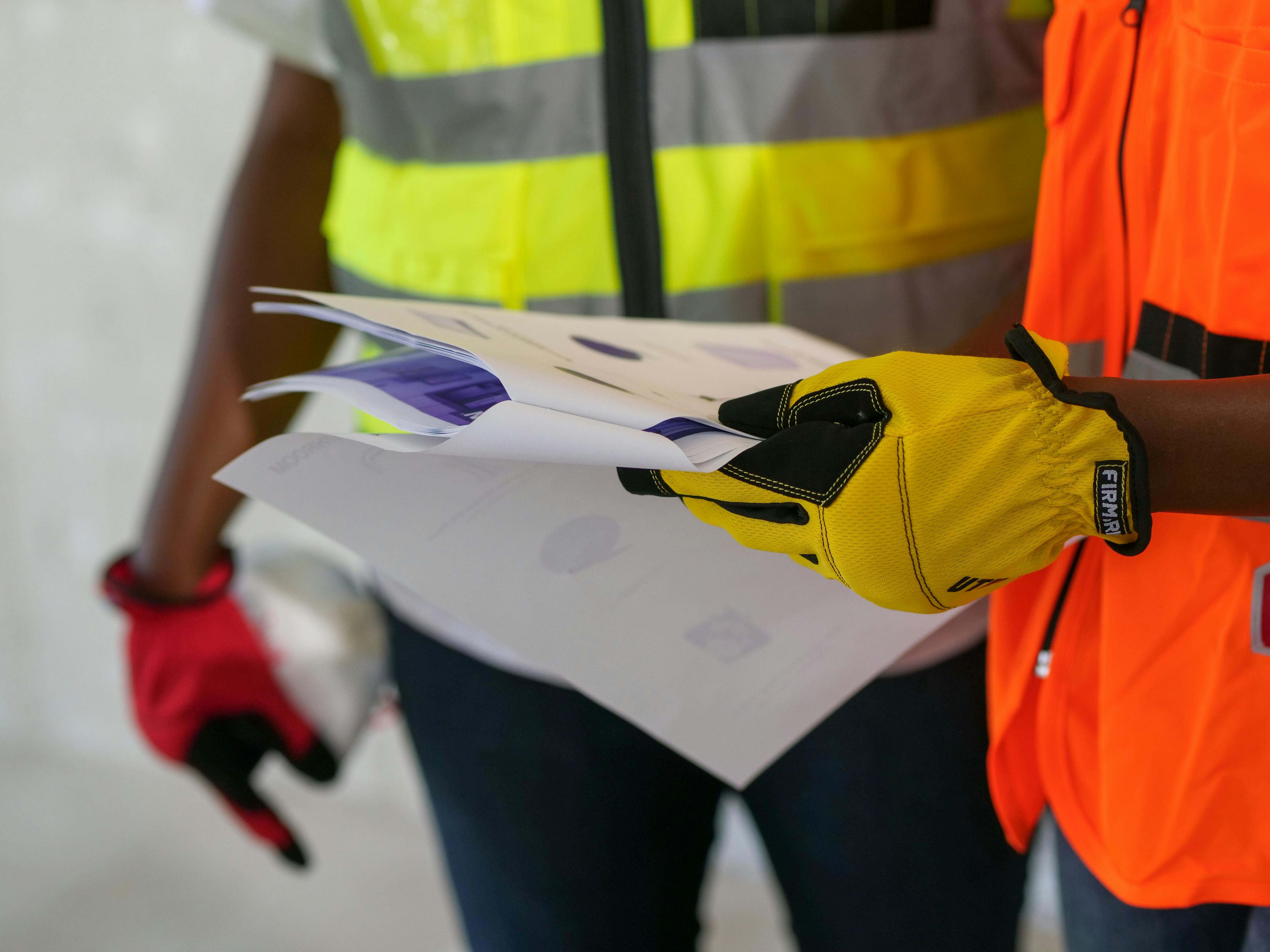 Construction worker reviewing building plans on site