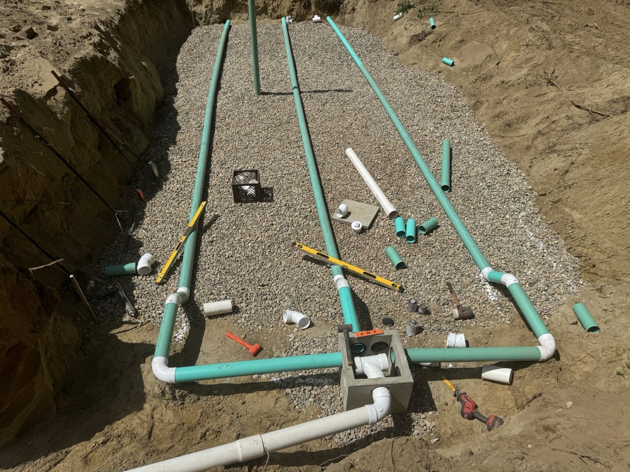 Overhead view of septic distribution pipes in a stone bed, A&M Construction jobsite