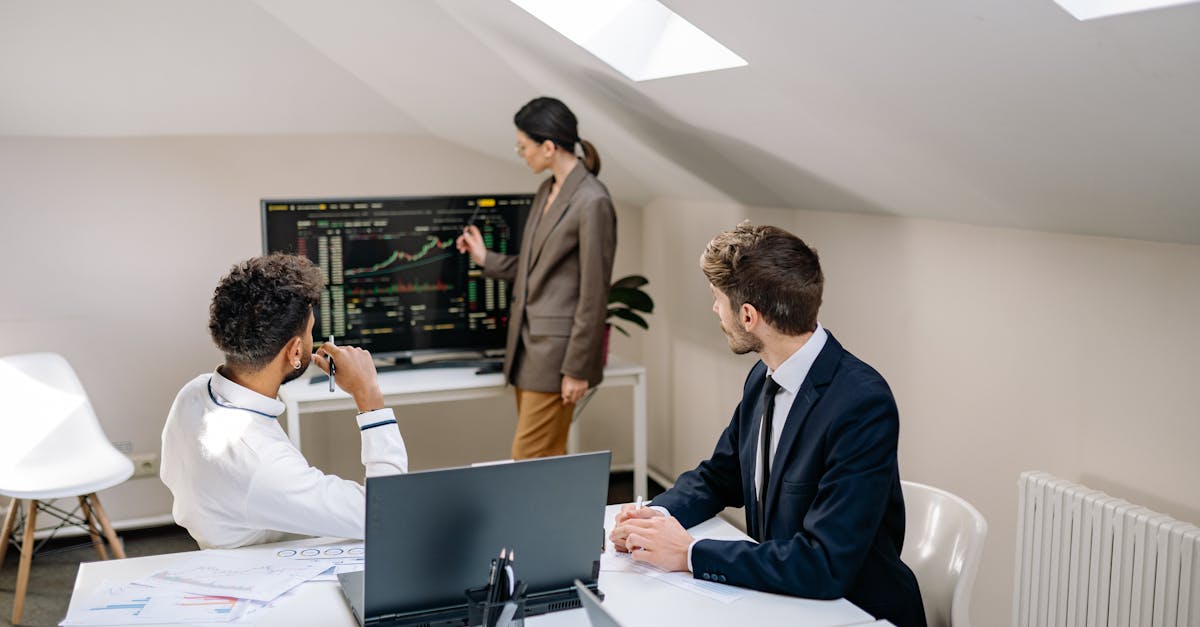 Professionals discussing stock market trends with charts in an office setting.