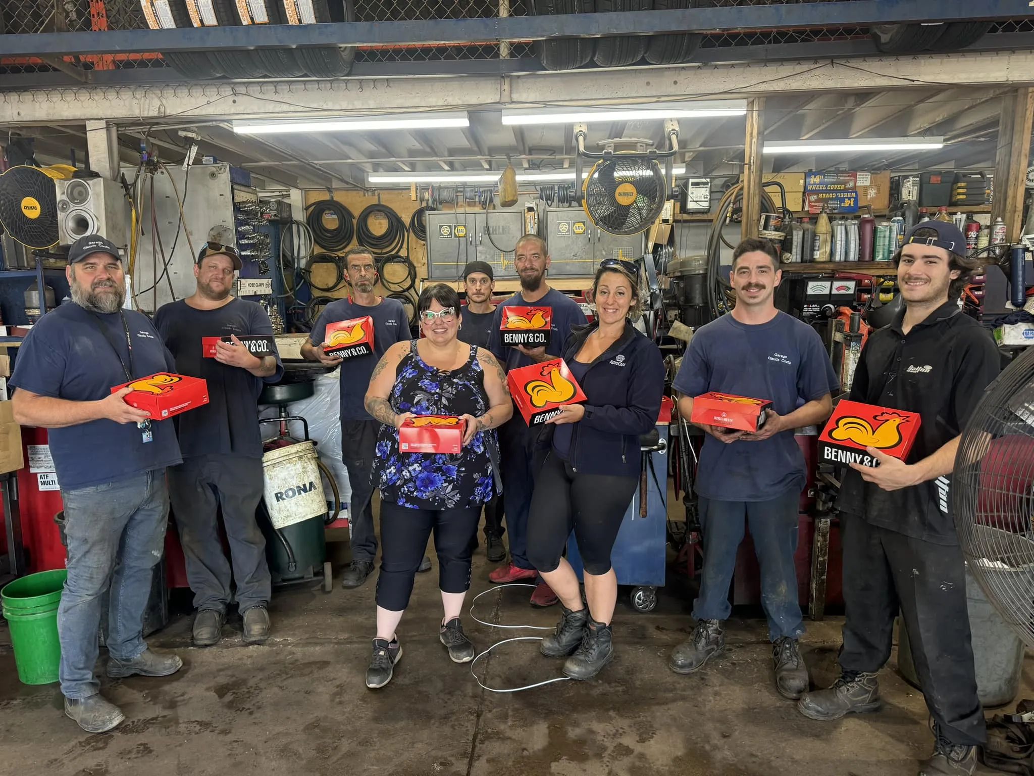 Équipe du Garage Claude Coutu posant avec des boîtes Benny & Co dans l’atelier mécanique, ambiance conviviale