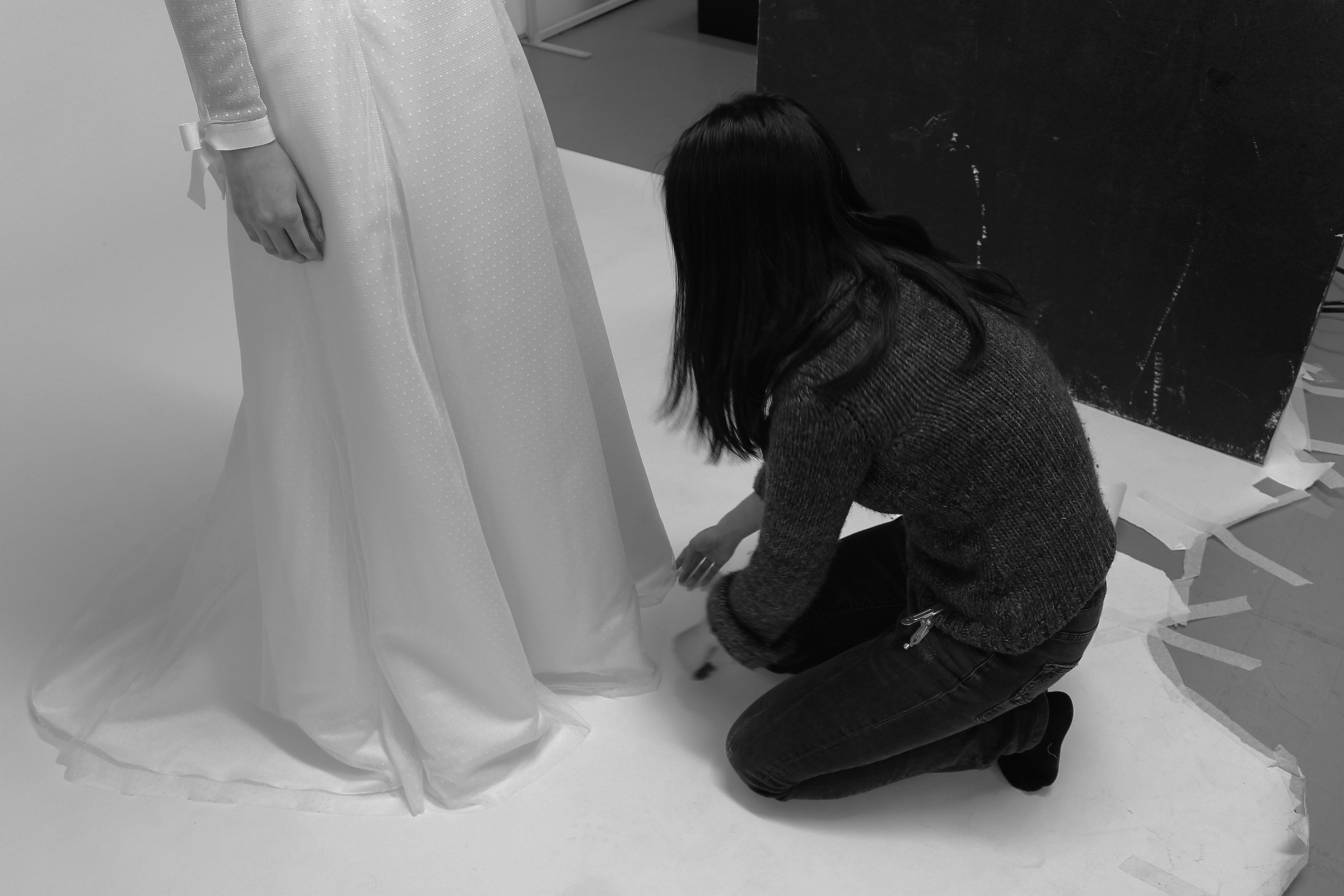 Photo of a wedding dress designer working on a dress for alterations