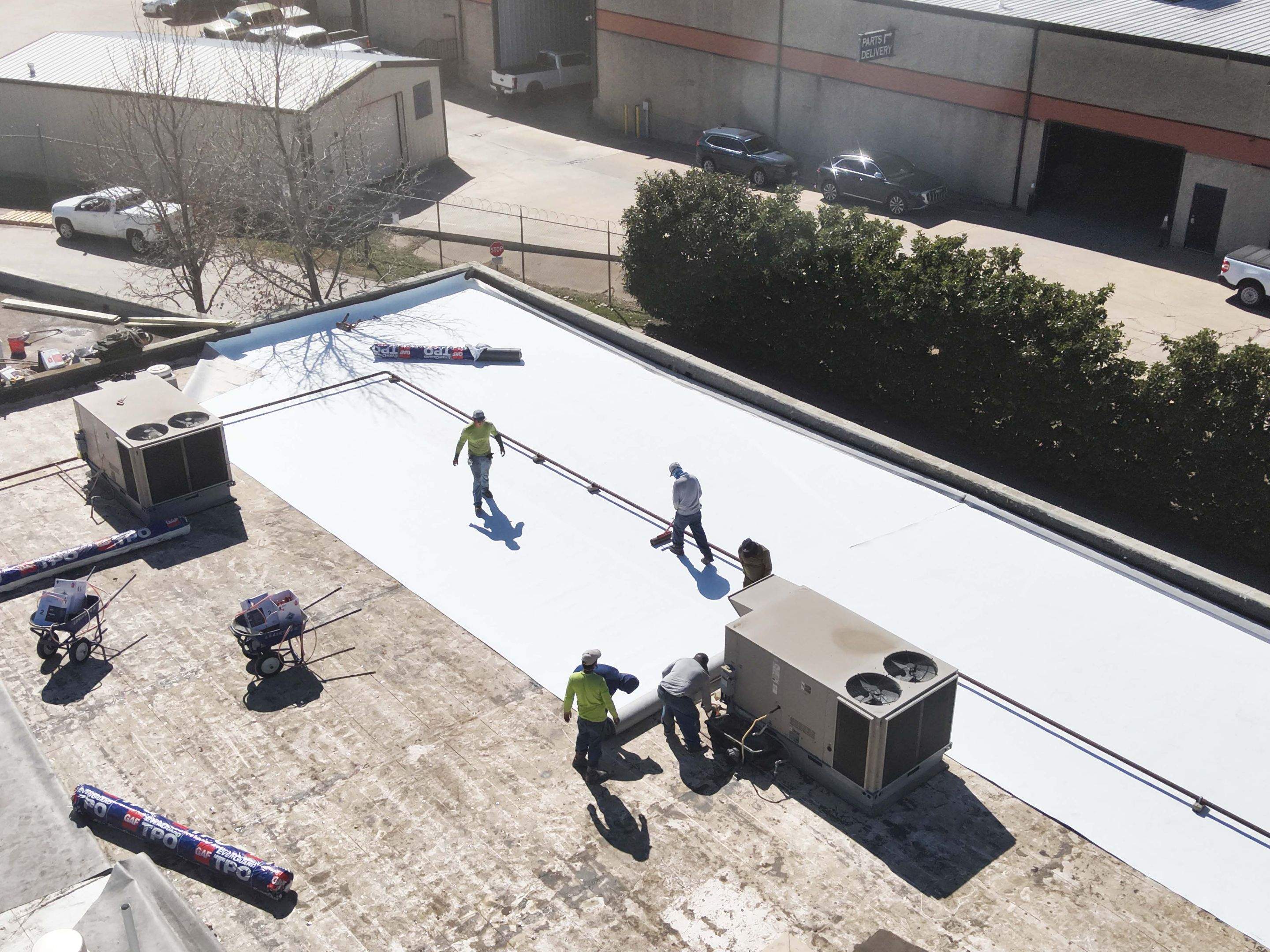 In progress drone shot showing the crew work on the TPO flat roof