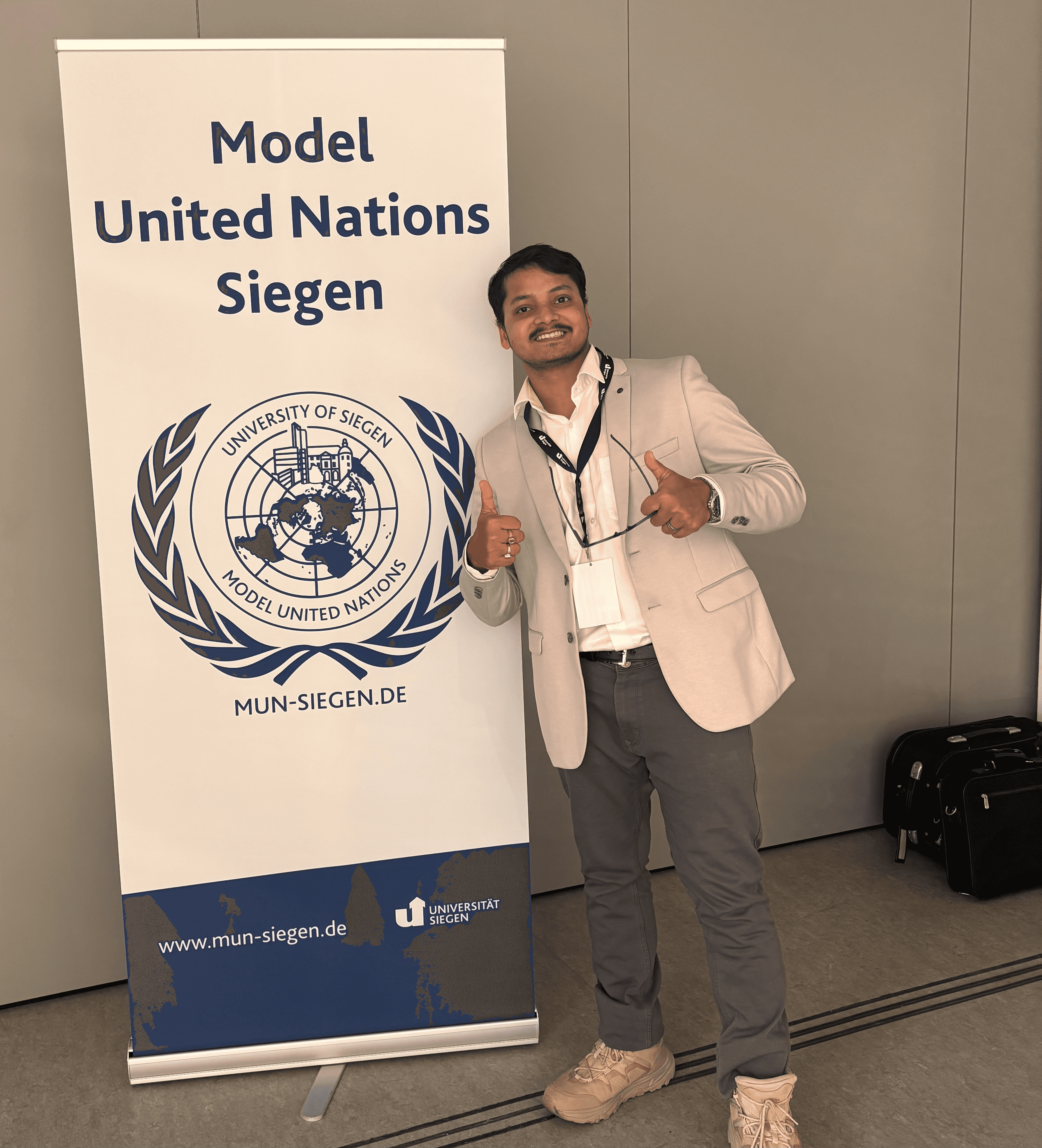 Person wearing a blue puffer jacket and red backpack standing in front of a light blue building on a city street.