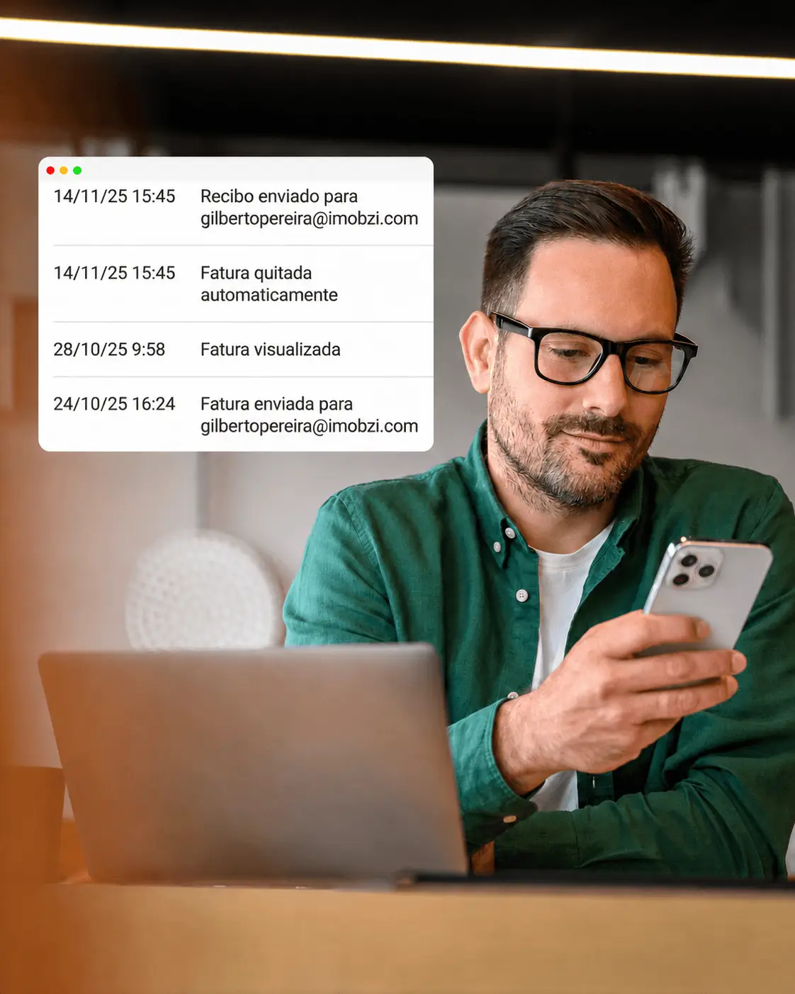 Profissional sorrindo usando celular ao lado de notebook em ambiente de trabalho