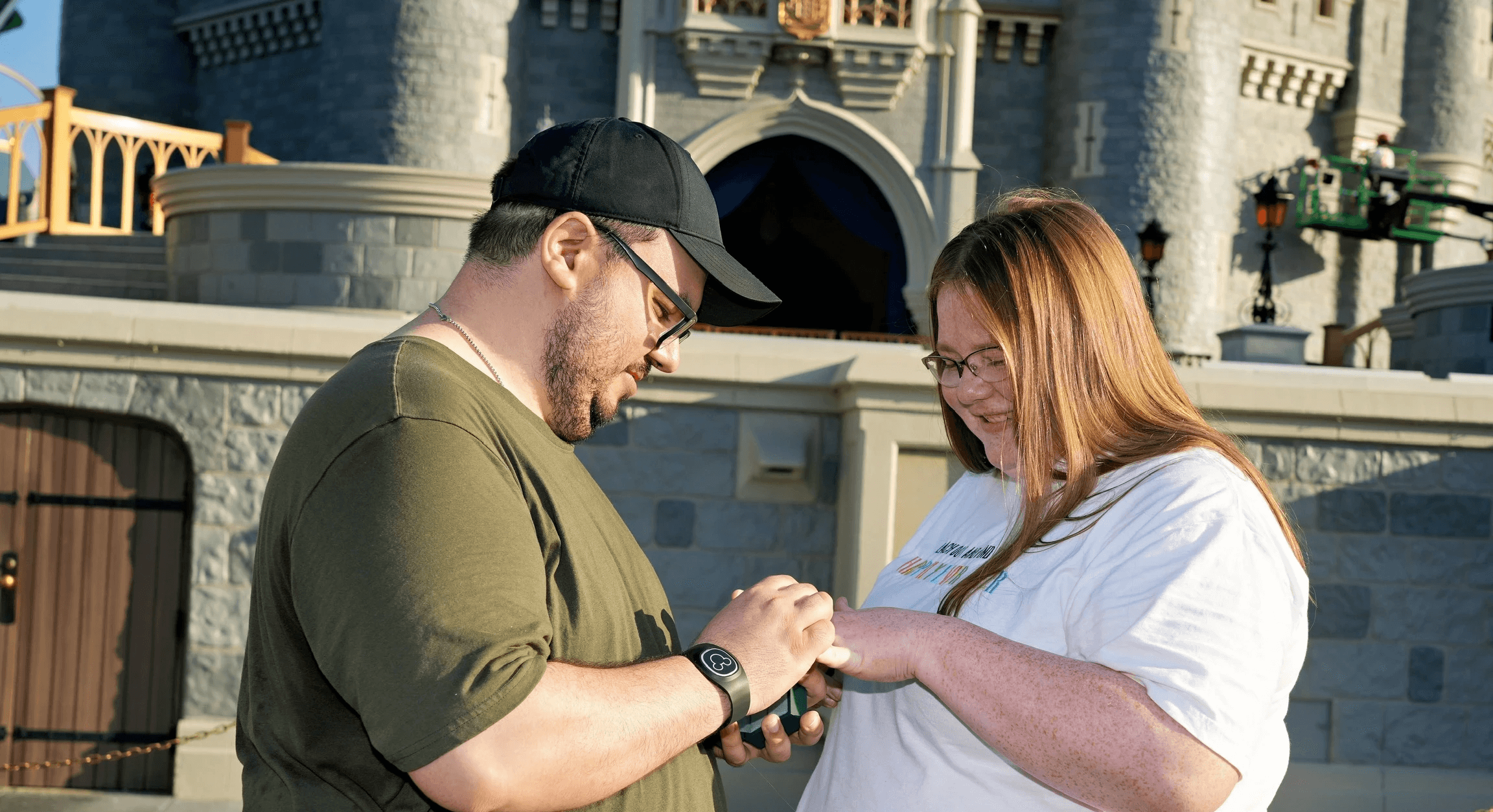woman holding a phone and man looking at the phone. both are smiling