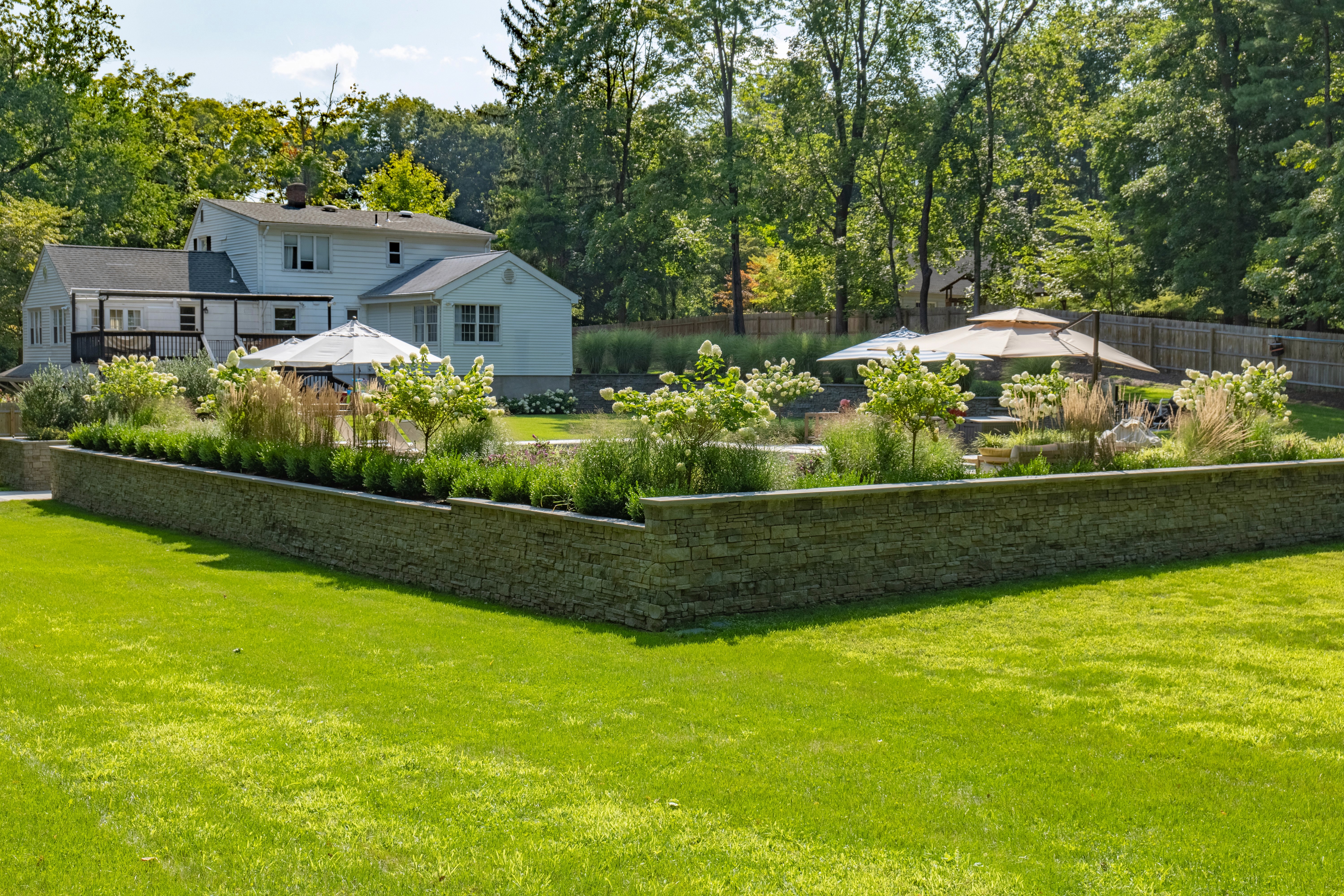 House with landscaped yard and stone retaining wall.