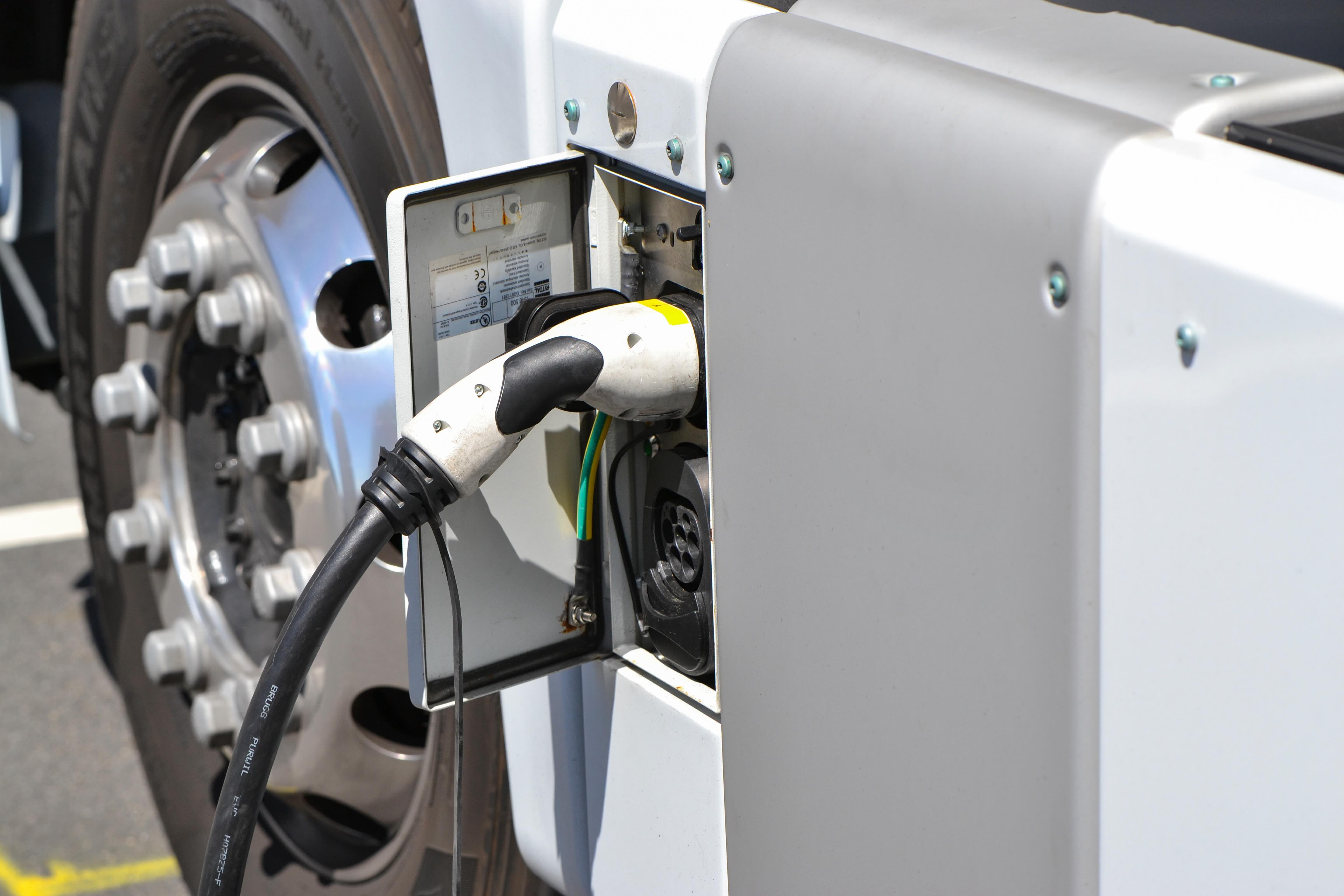 Electric truck parked at a high-capacity charging station, illustrating the need for expanded infrastructure.