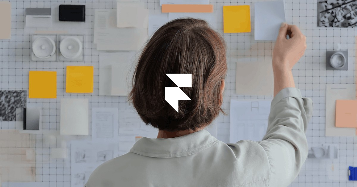 A person looking at a wall covered with papers, photos, and colorful notes, arranging or planning something.