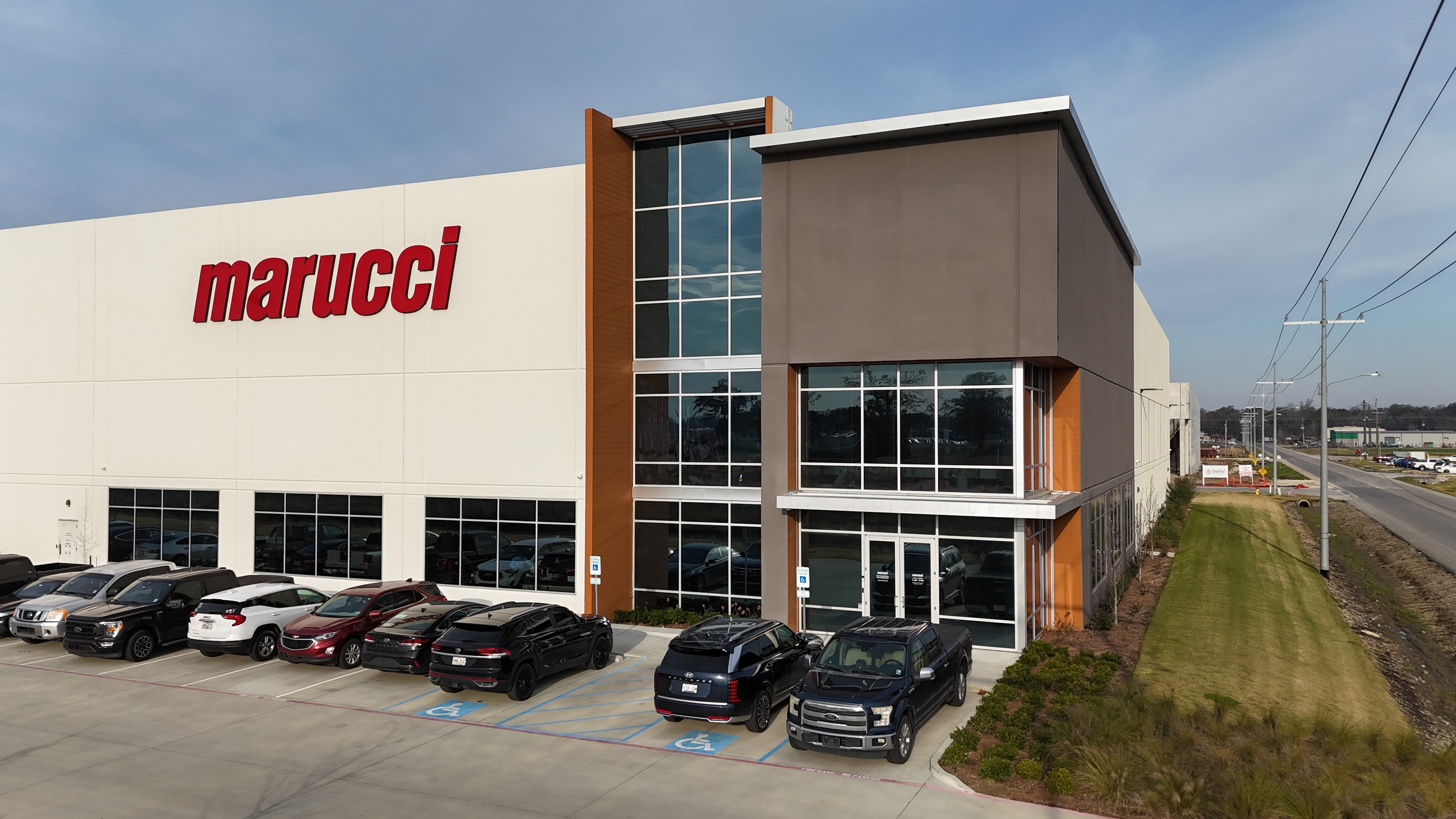 Front corner view of the Rivermark Phase I warehouse with Marucci signage and employee parking.