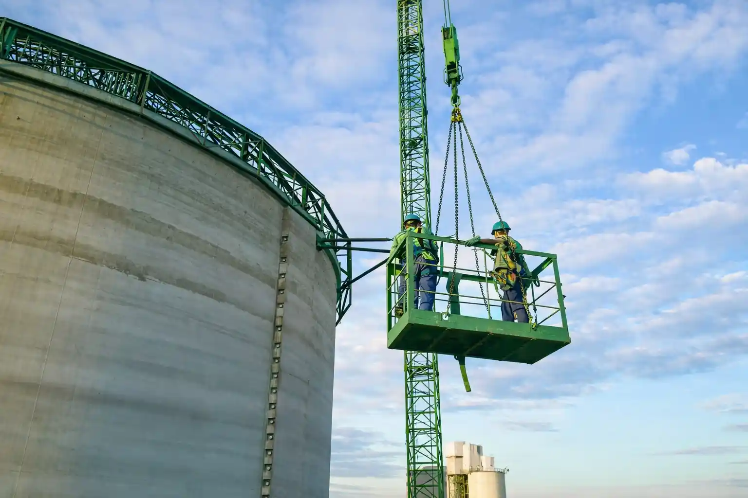 Large industrial cement storage tank with crane during plant construction