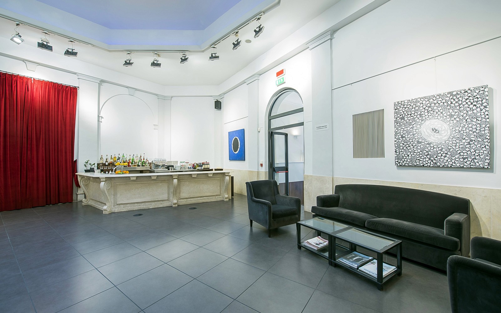 Hall d'accueil d'une salle de concert d'opéra à Rome, comprenant des places assises et un espace bar.