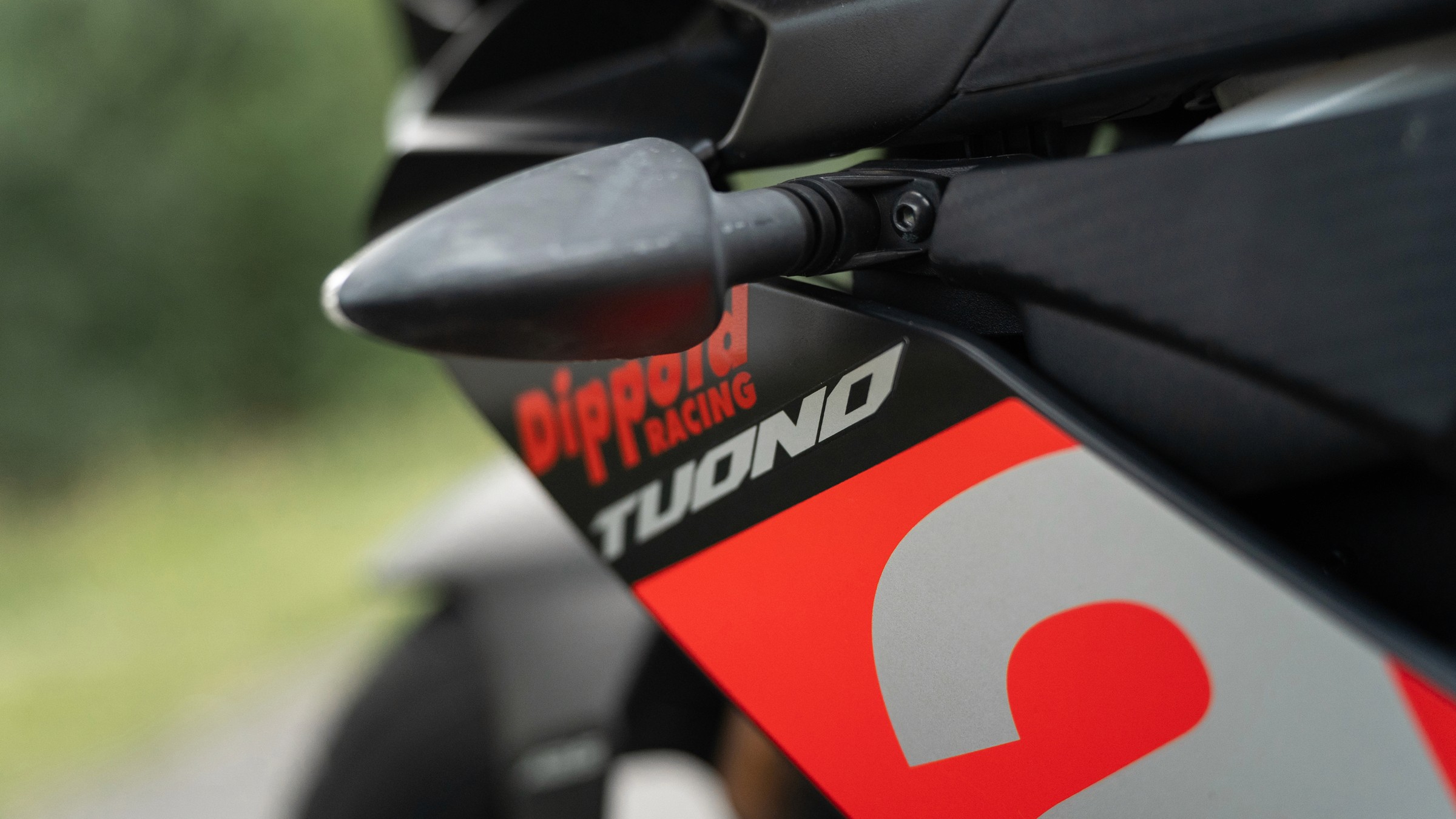 Detailaufnahme des Schriftzugs „Tuono“ am A1/B196-Fahrschulmotorrad in Neustadt bei Coburg & Rödental.