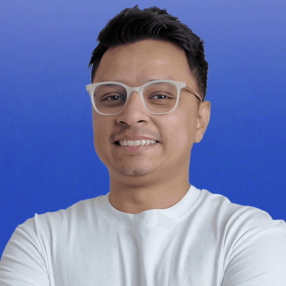 Black and white portrait of a smiling woman with blonde hair and crossed arms, exuding confidence and warmth.