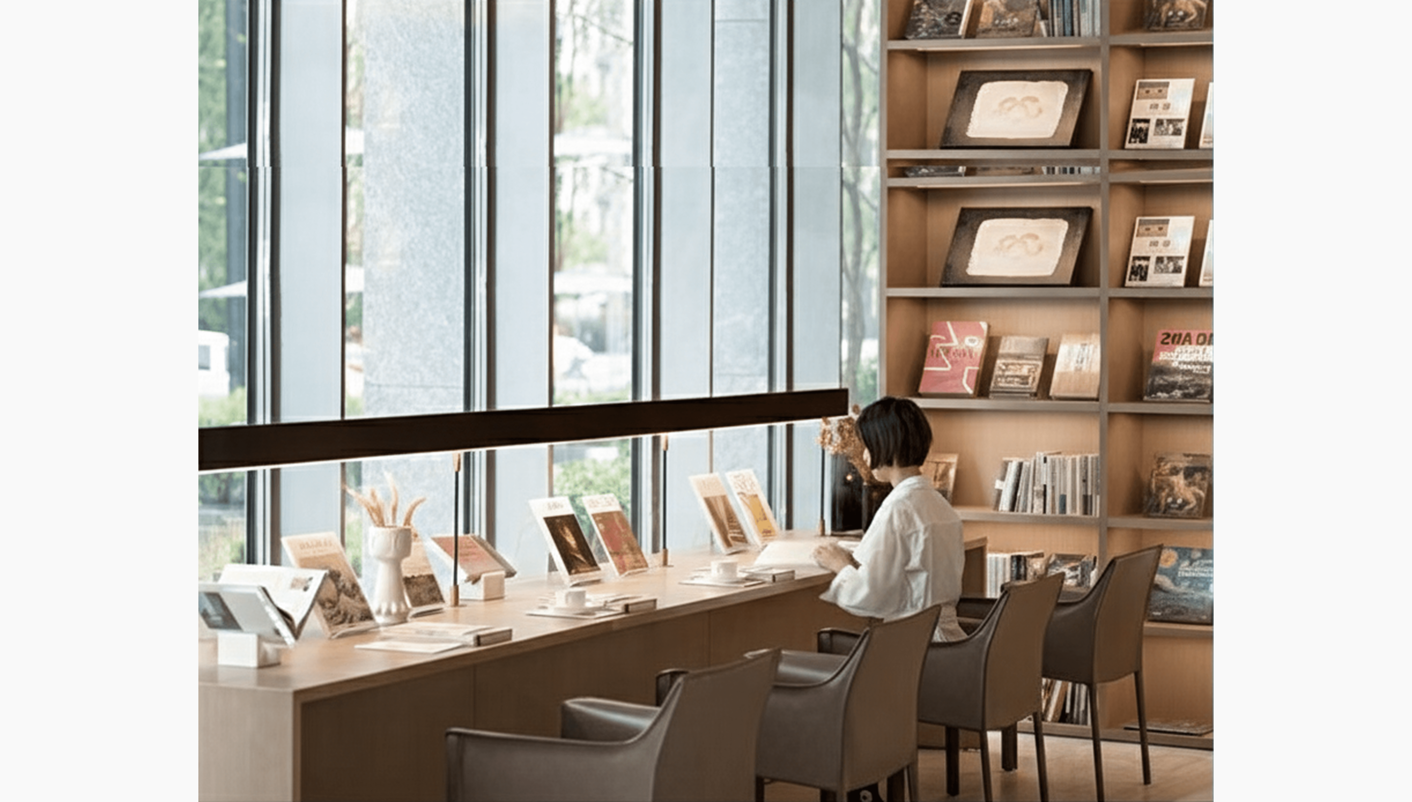 창가에 앉아 책을 읽고 있는 디자이너