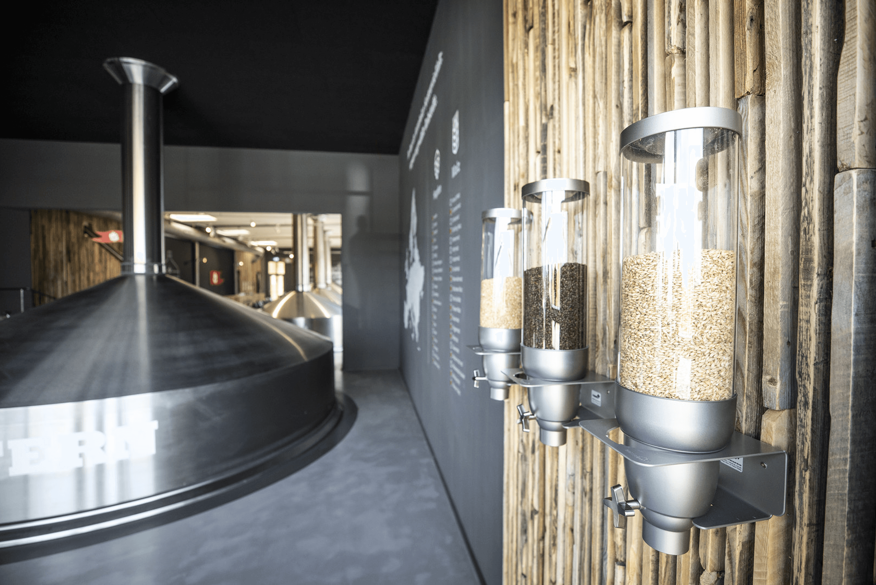 Three dispensers with grain on a wooden wall.