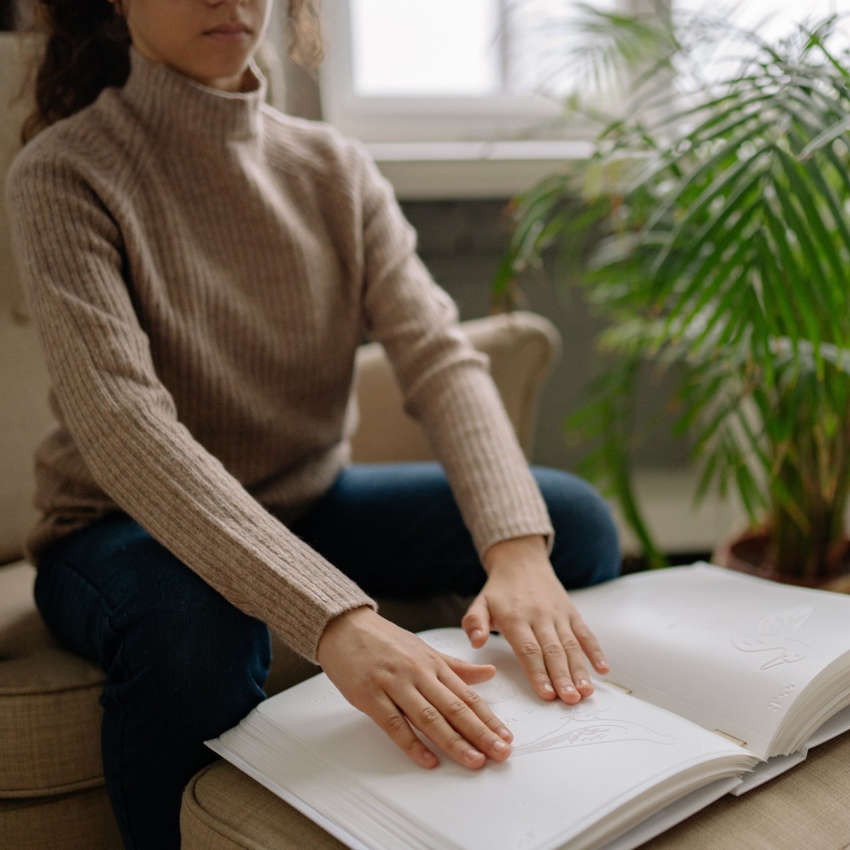 A lady reading a braille book