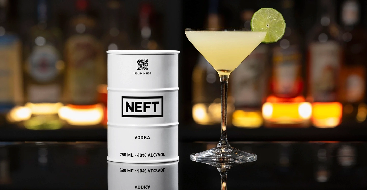 A NEFT Barrel and a Kamikaze martini on a bar counter.