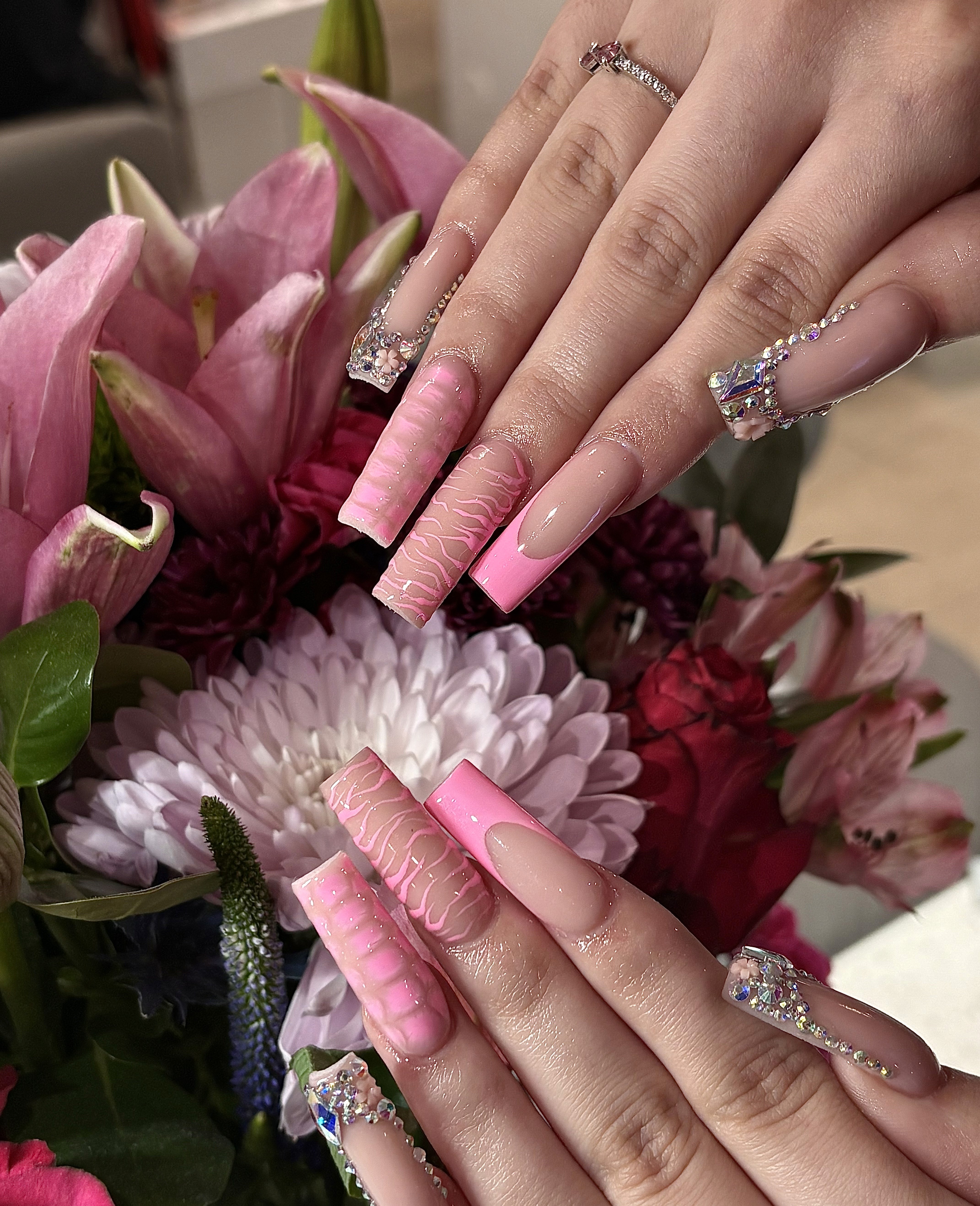 Long acrylic nails with bold pink and black design at Naperville nail salon