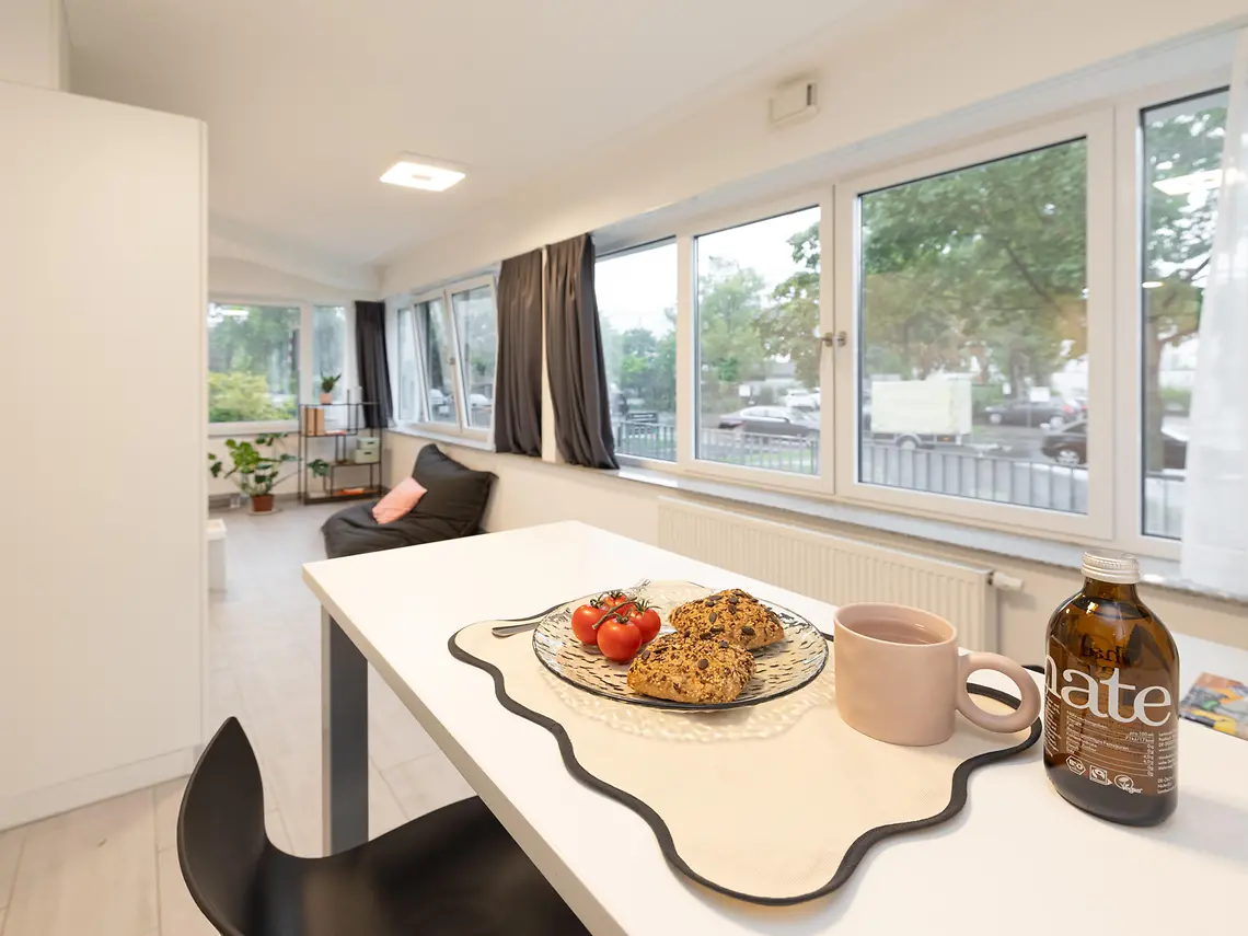 Dining and living area in a student studio in Darmstadt with large windows
