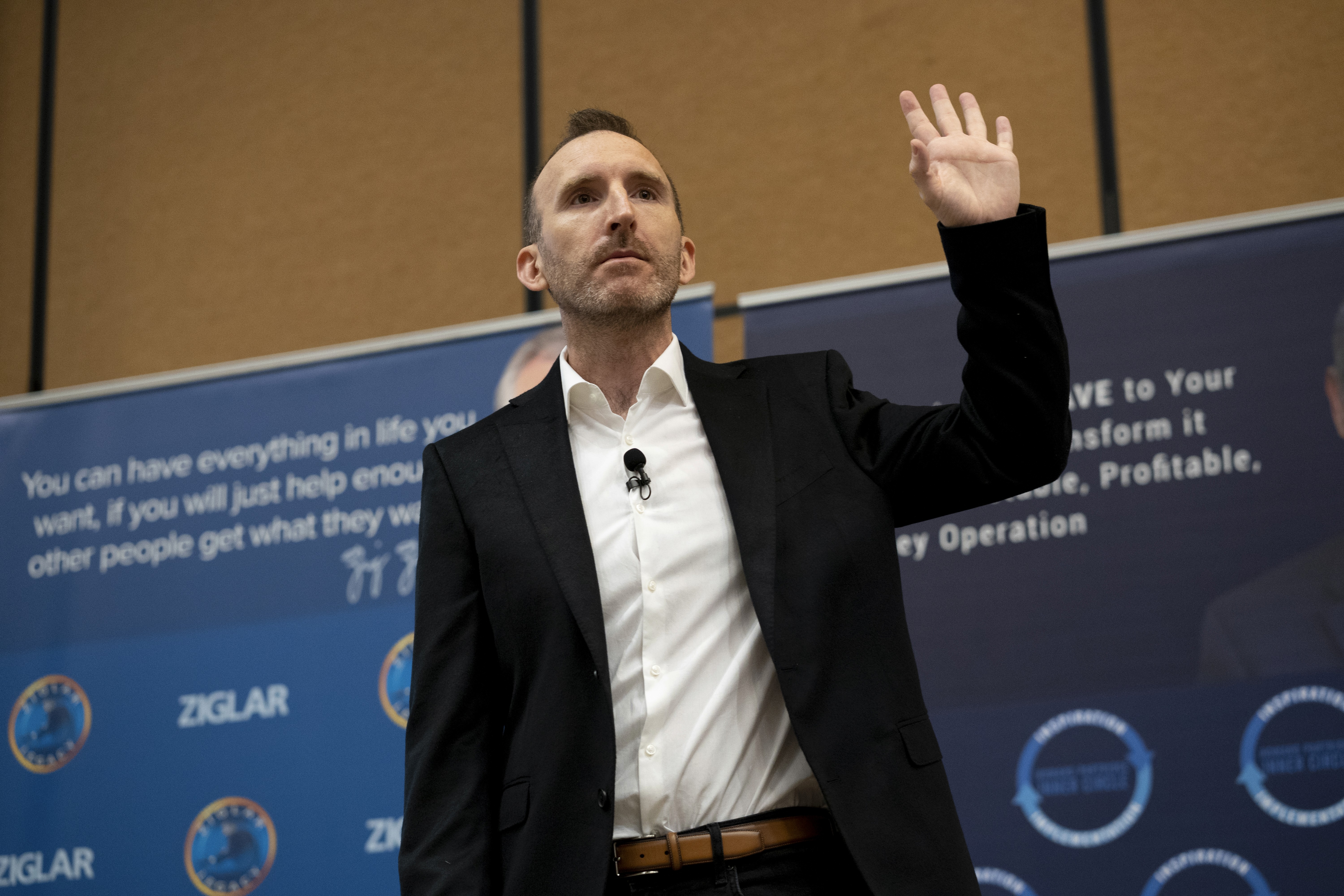A cute 3D fuzzy black cat with bright orange eyes and a soft textured surface, sitting against a beige background.