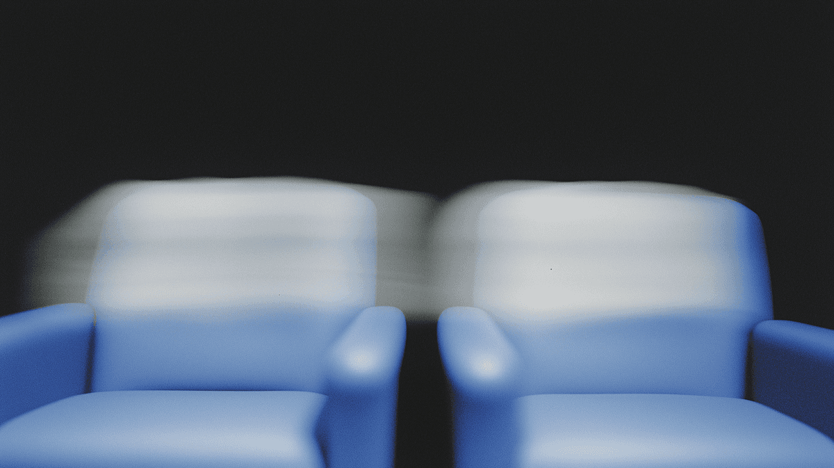 Blue chairs in a neat row against a light gray background, creating a minimalist and modern aesthetic.