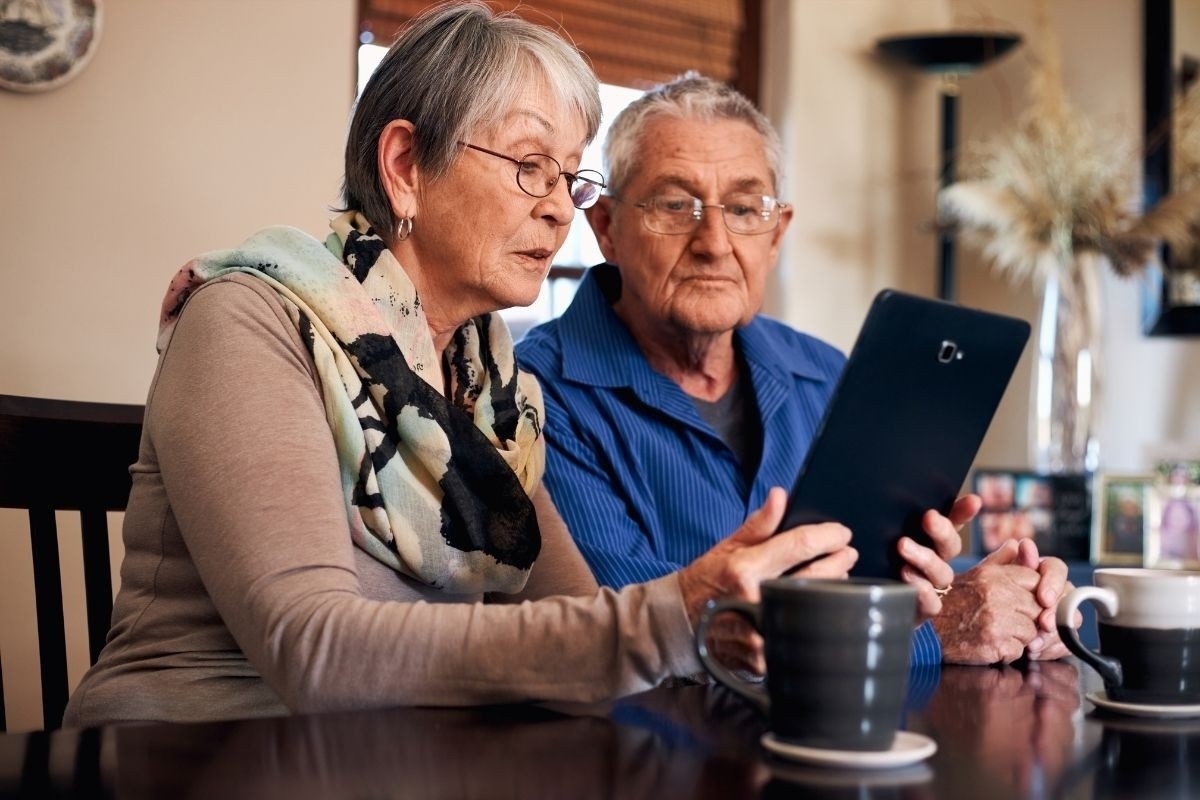 Senior couple reading an ipad.