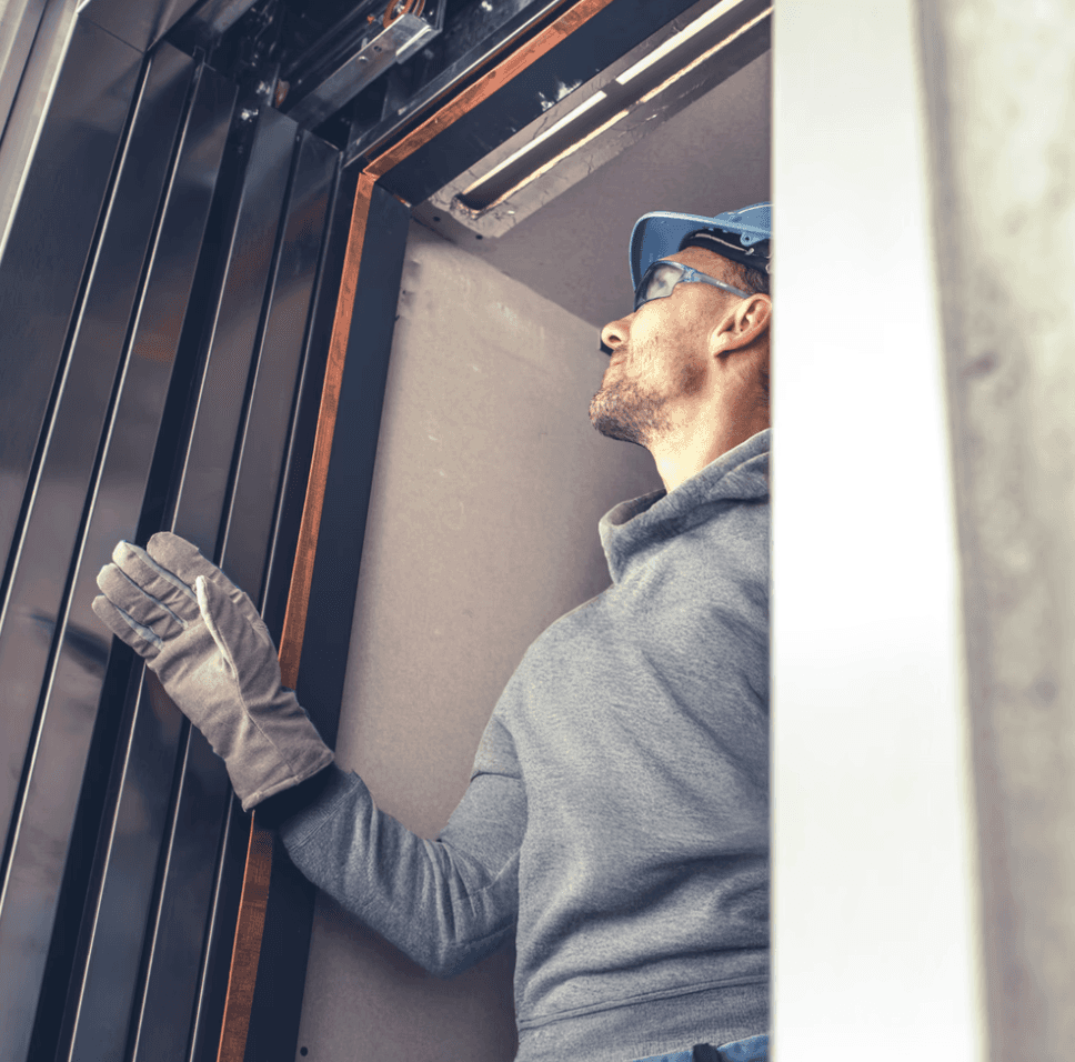 Técnico de ascensores realizando mantenimiento y reparaciones de ascensores con sistema de gestión digital en tiempo real