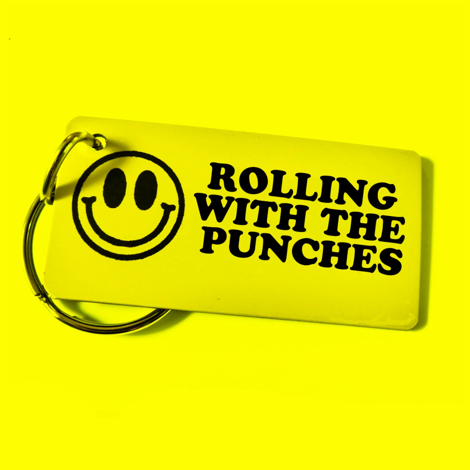 Yellow Rolling with the Punches key tag with a smiley graphic.