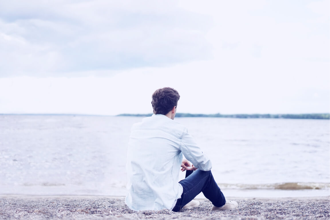 men's sexual health man looking at ocean on beach facing forward