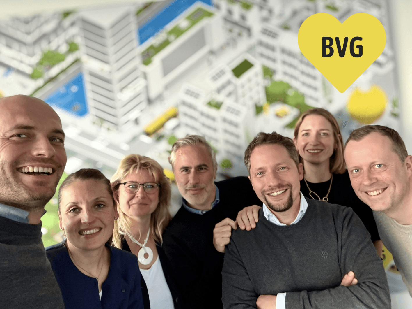 A smiling person with curly hair, wearing a leather jacket, stands in a cozy indoor setting.