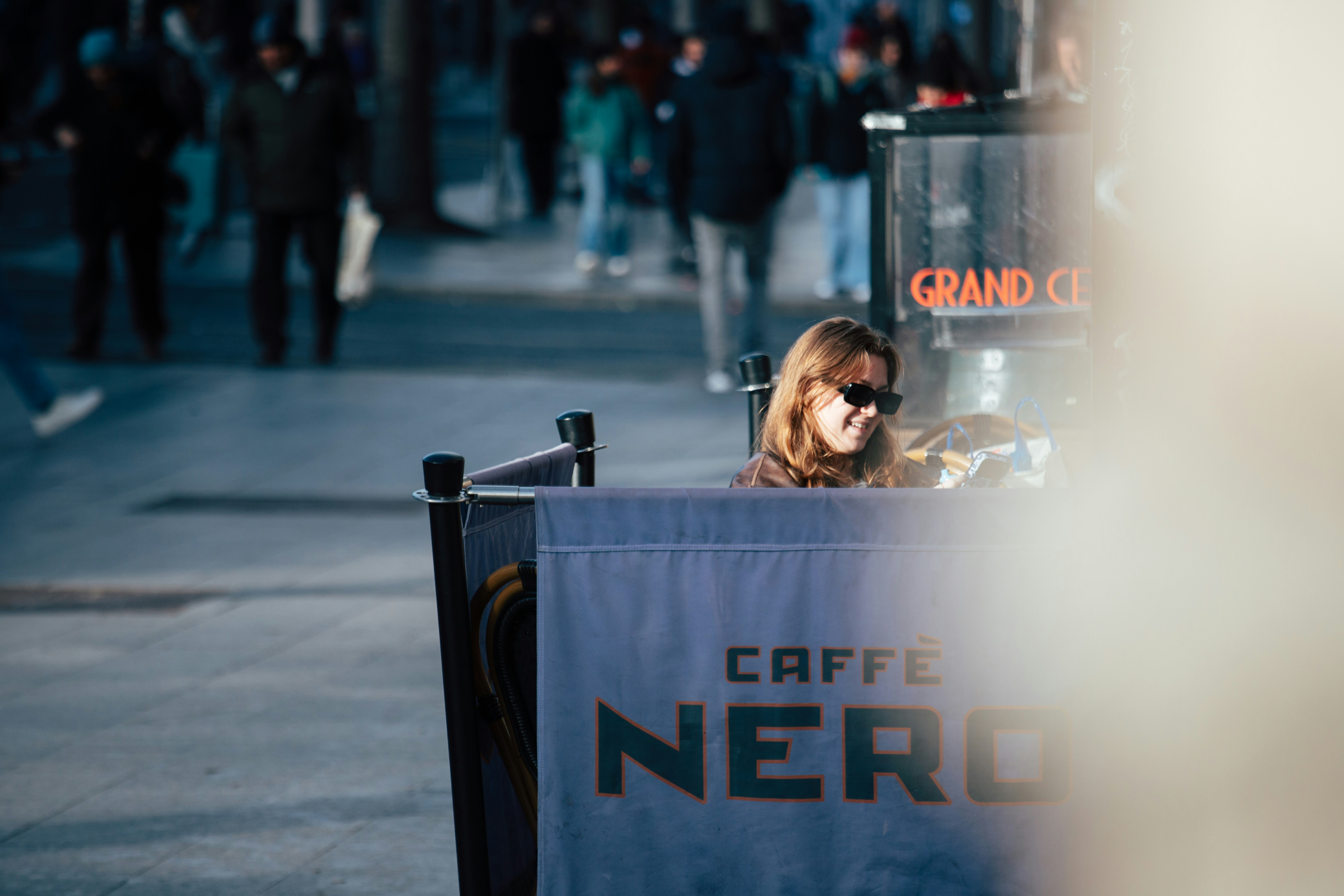 woman-sitting-at-a-cafe-with-caffe-nero-sign - atelierbyvineeth-... (unsplash)./pho