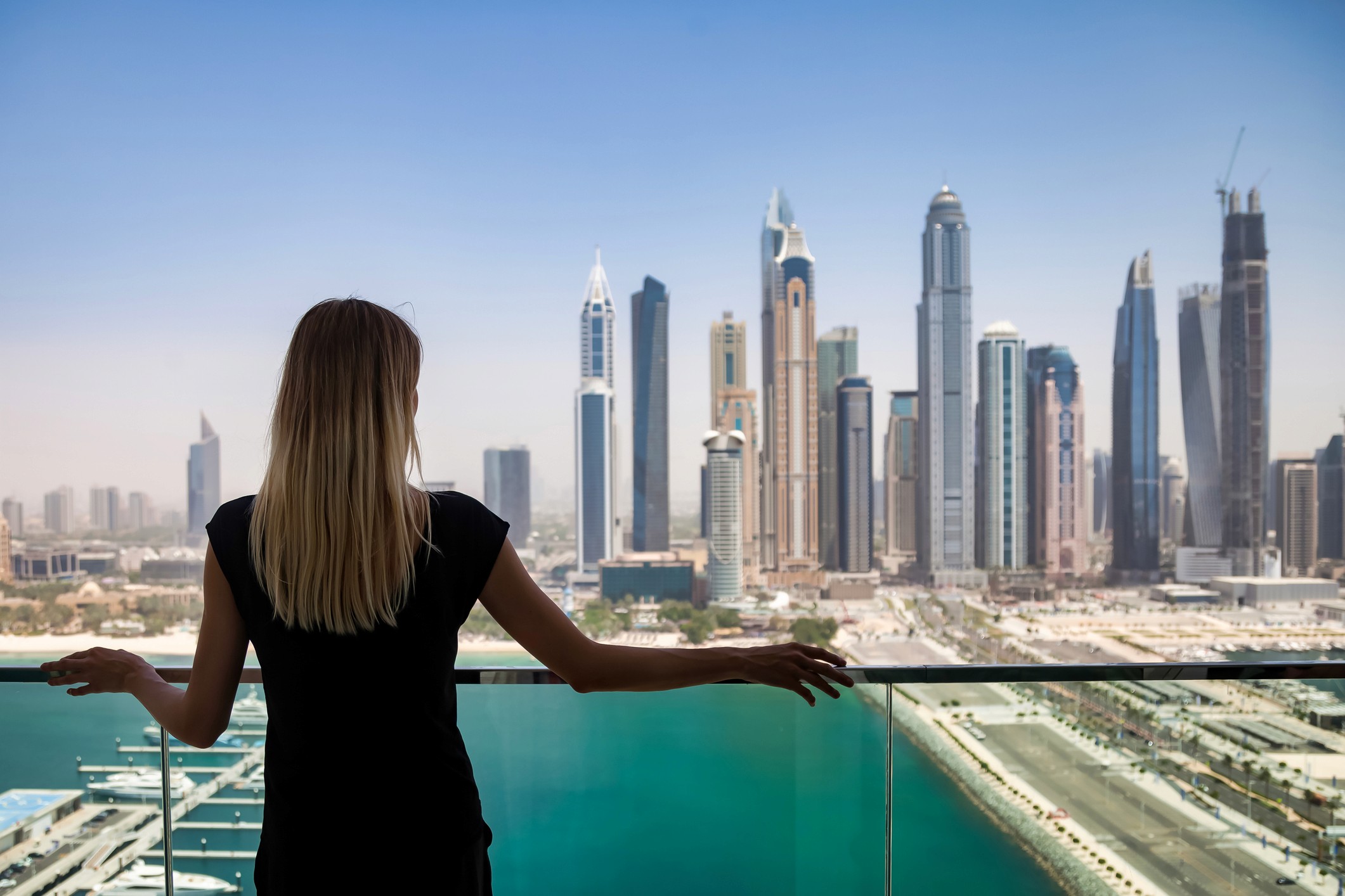 A lady on a balcony overlooking the Dubai Marina
