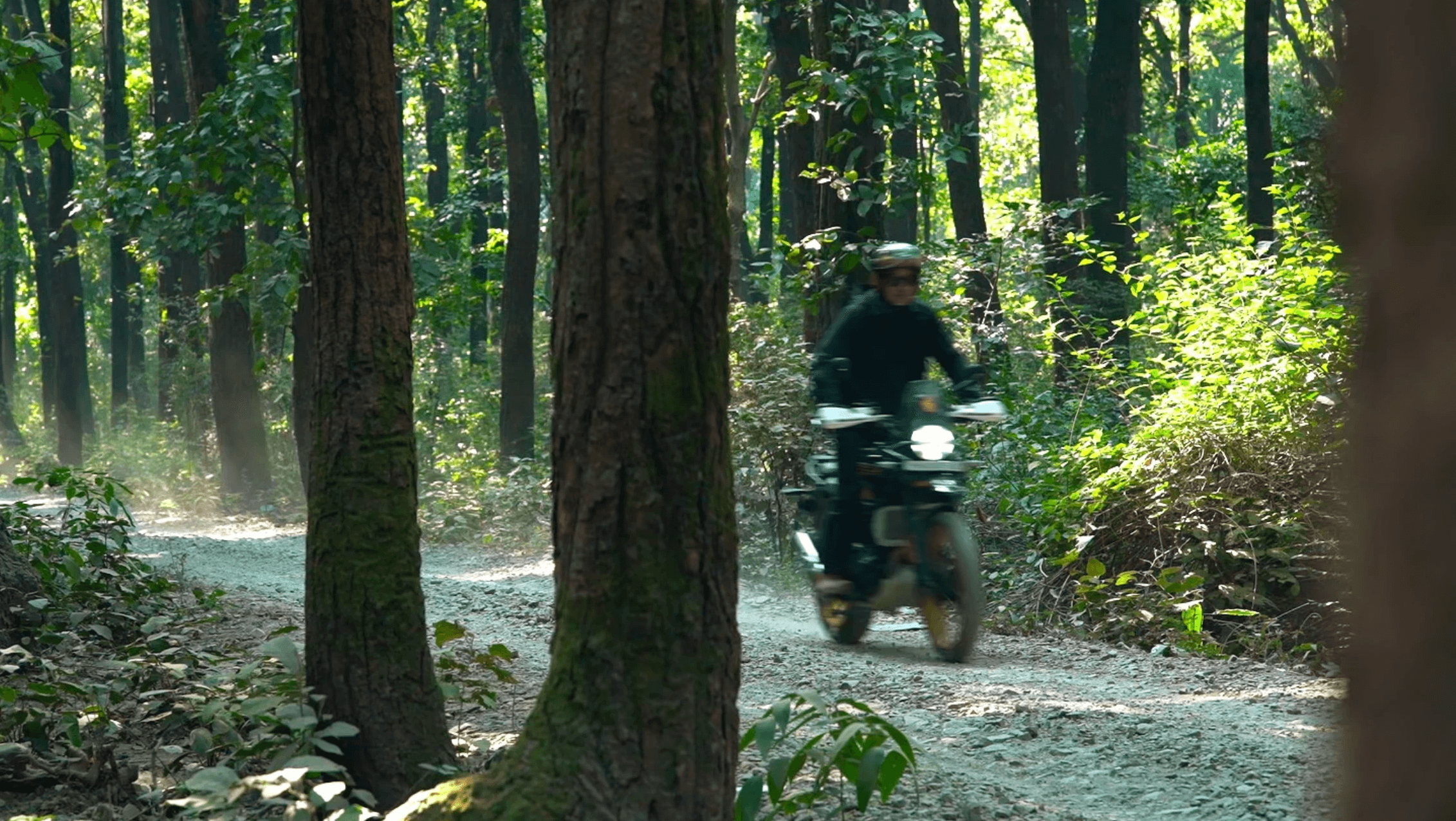 Black-and-white photo of a band rehearsal with guitarist, drummer, and people gathered under string lights.