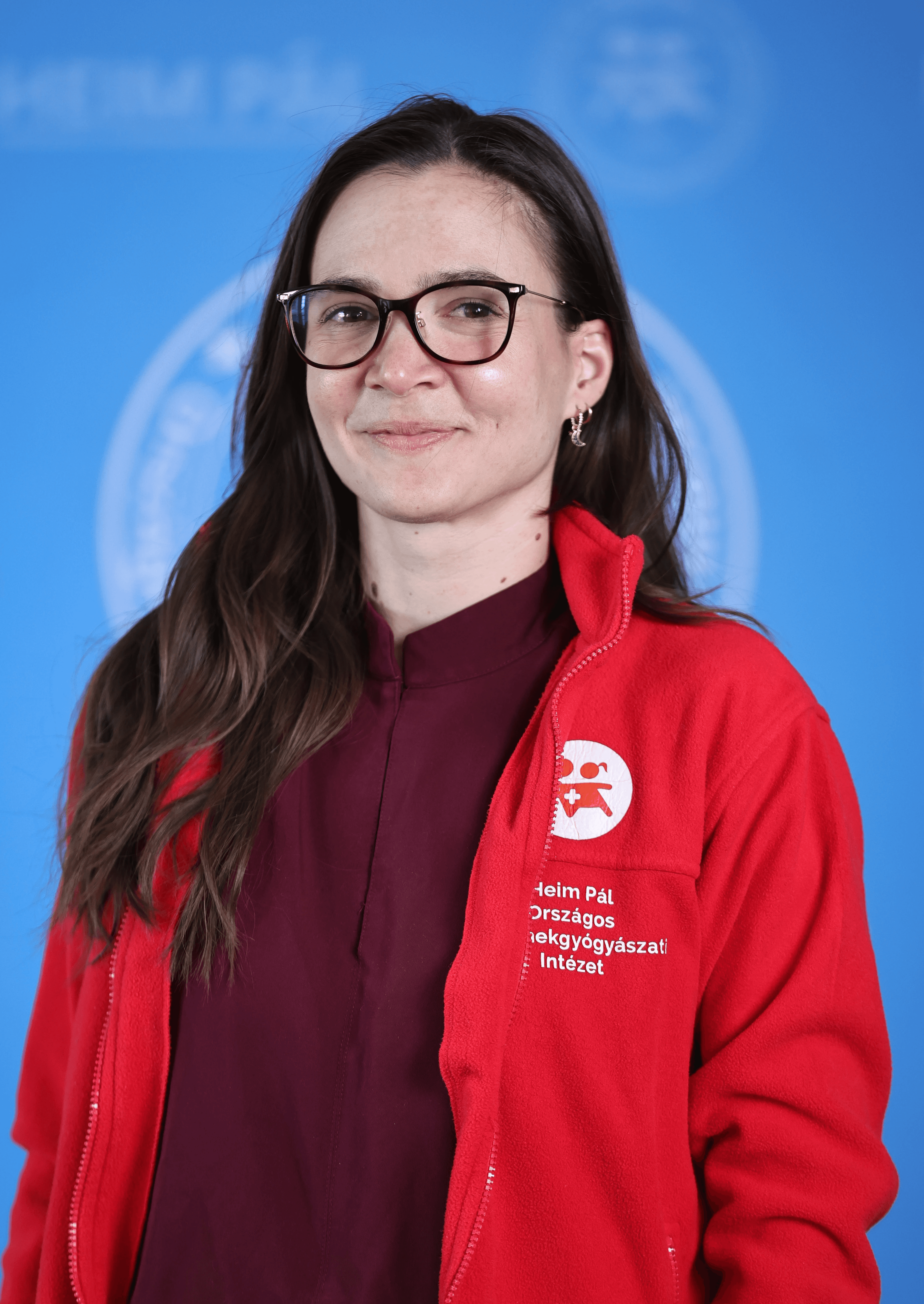 Hosszúhajú szemüveges nő piros kardigánban