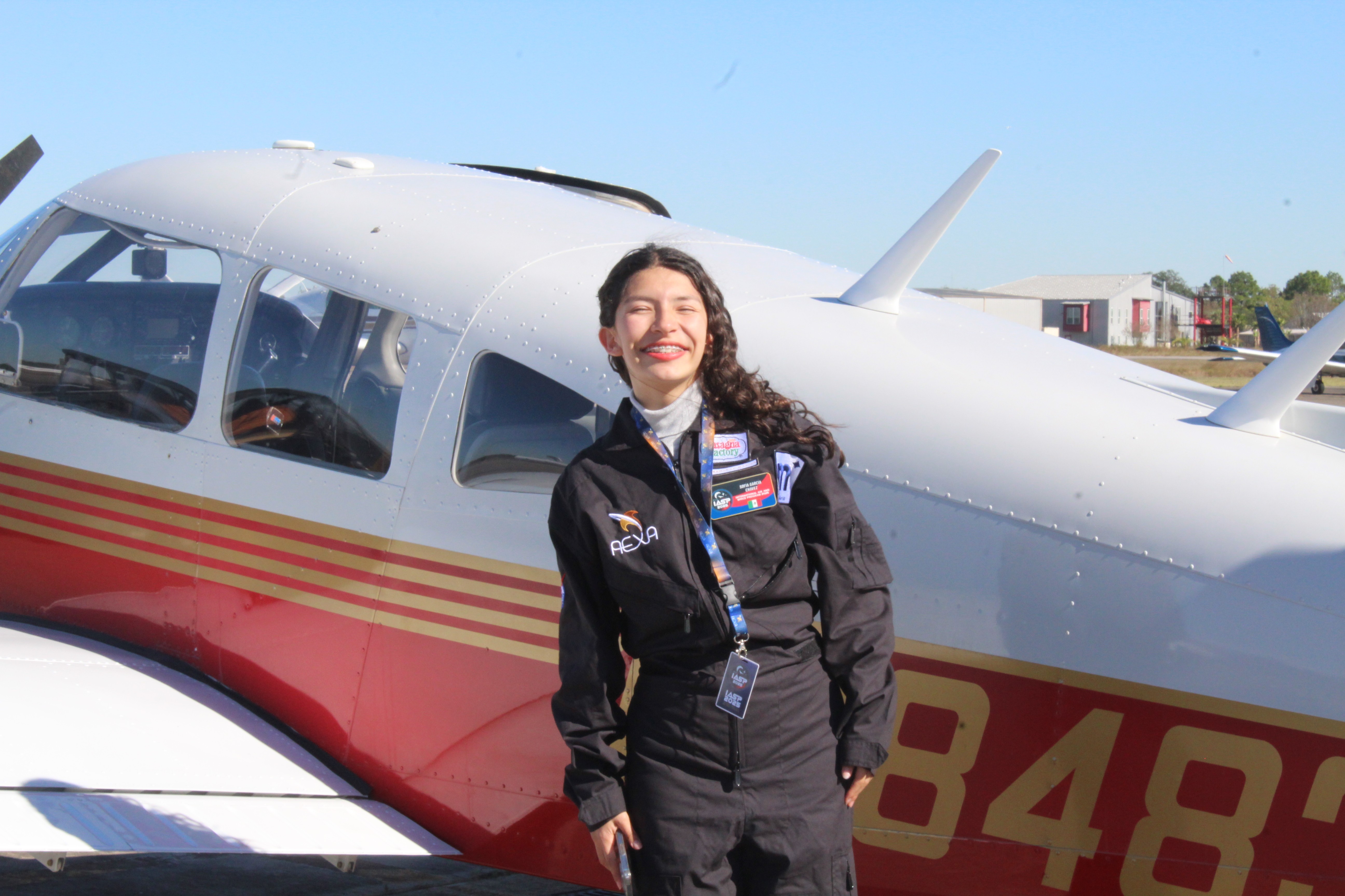 Sofía poses next to her aircraft at the International Air and Space Program in 2025.
