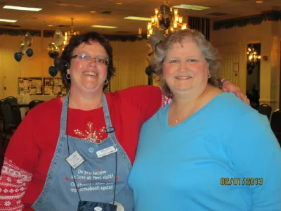 Shelley (left) in her apron posing with a friend at a crop in a banquet hall