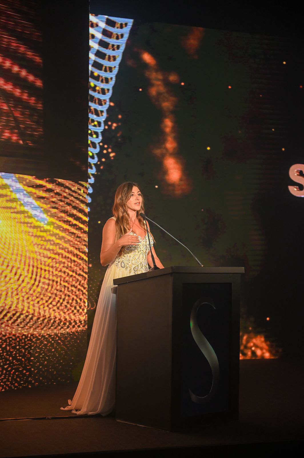 Dubai event host on stage with branded screen during a corporate event by an entertainment agency Dubai