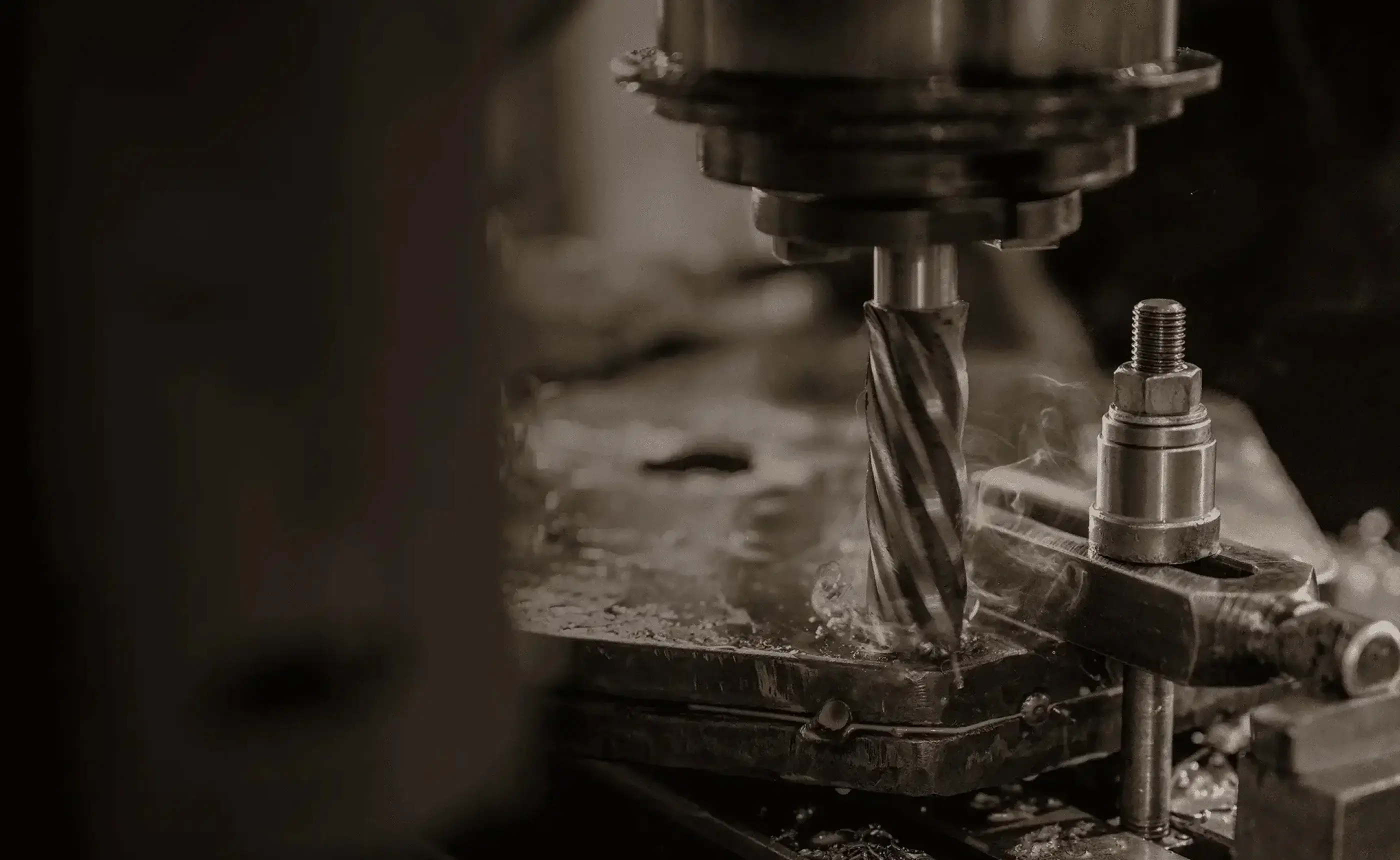 A metal rod held in a lathe chuck being machined by a cutting tool
