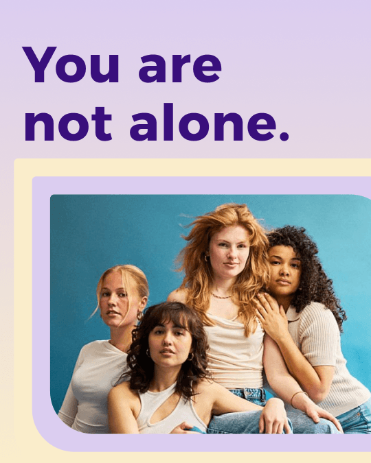 "You are not alone." Bold typography above a photo of a diverse group of four women on a soft pink background.