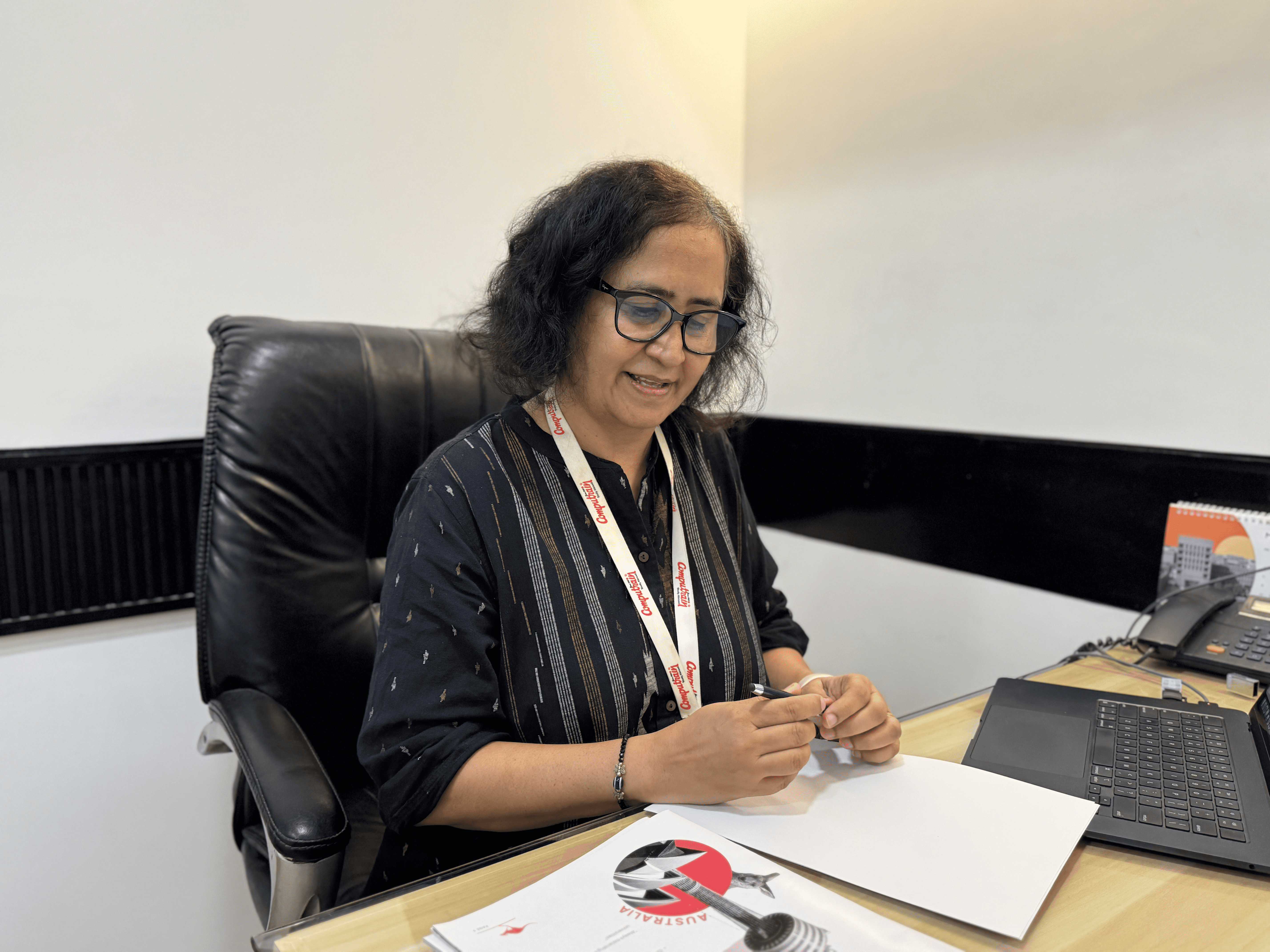 three people sitting in front of table laughing together