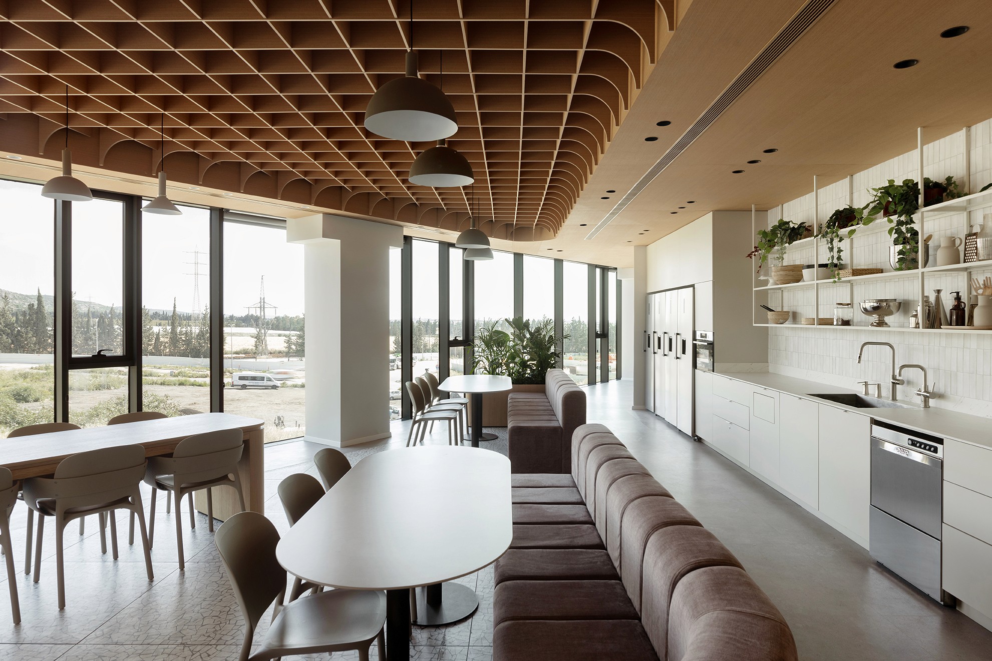 חדשנות בחומרים: תקרה אקוסטית מודפסת במראה עץ (Wood-Look Acoustic Ceiling) במטבח הראשי – יצירת אווירה חמה וביתית תוך שמירה על בליעת רעשים מקסימלית