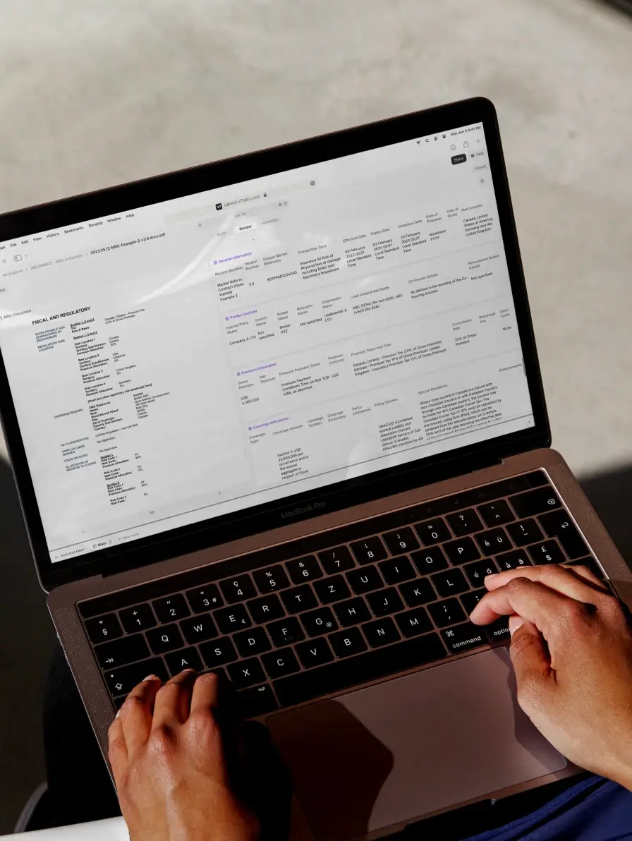 Hands typing on a laptop displaying a document.